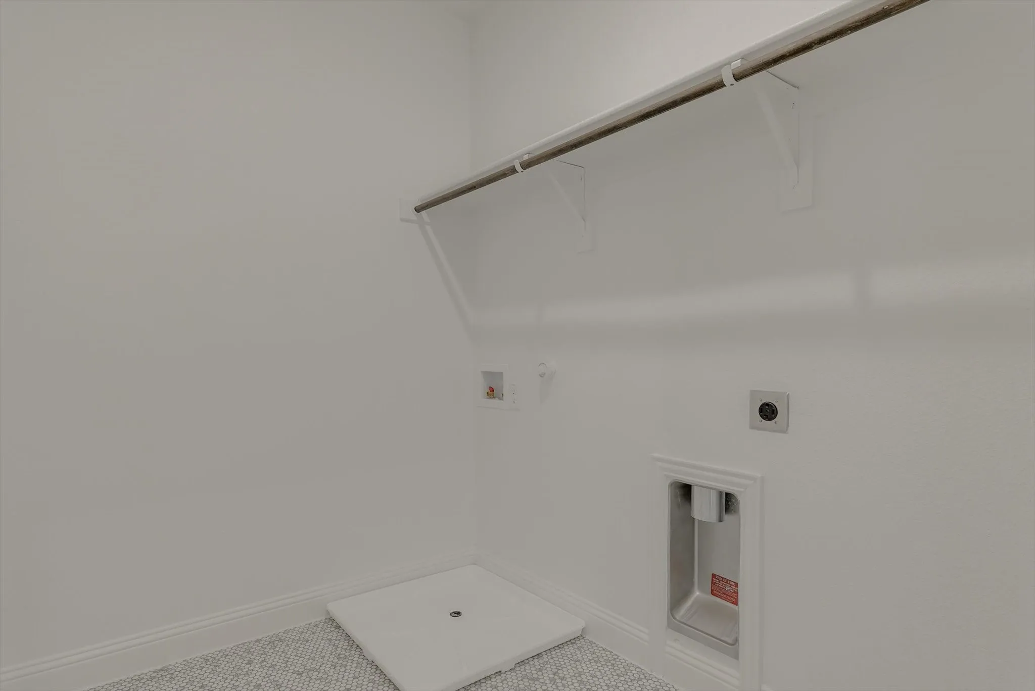 Laundry area featuring a hanging rod, tile flooring, and utility hookups