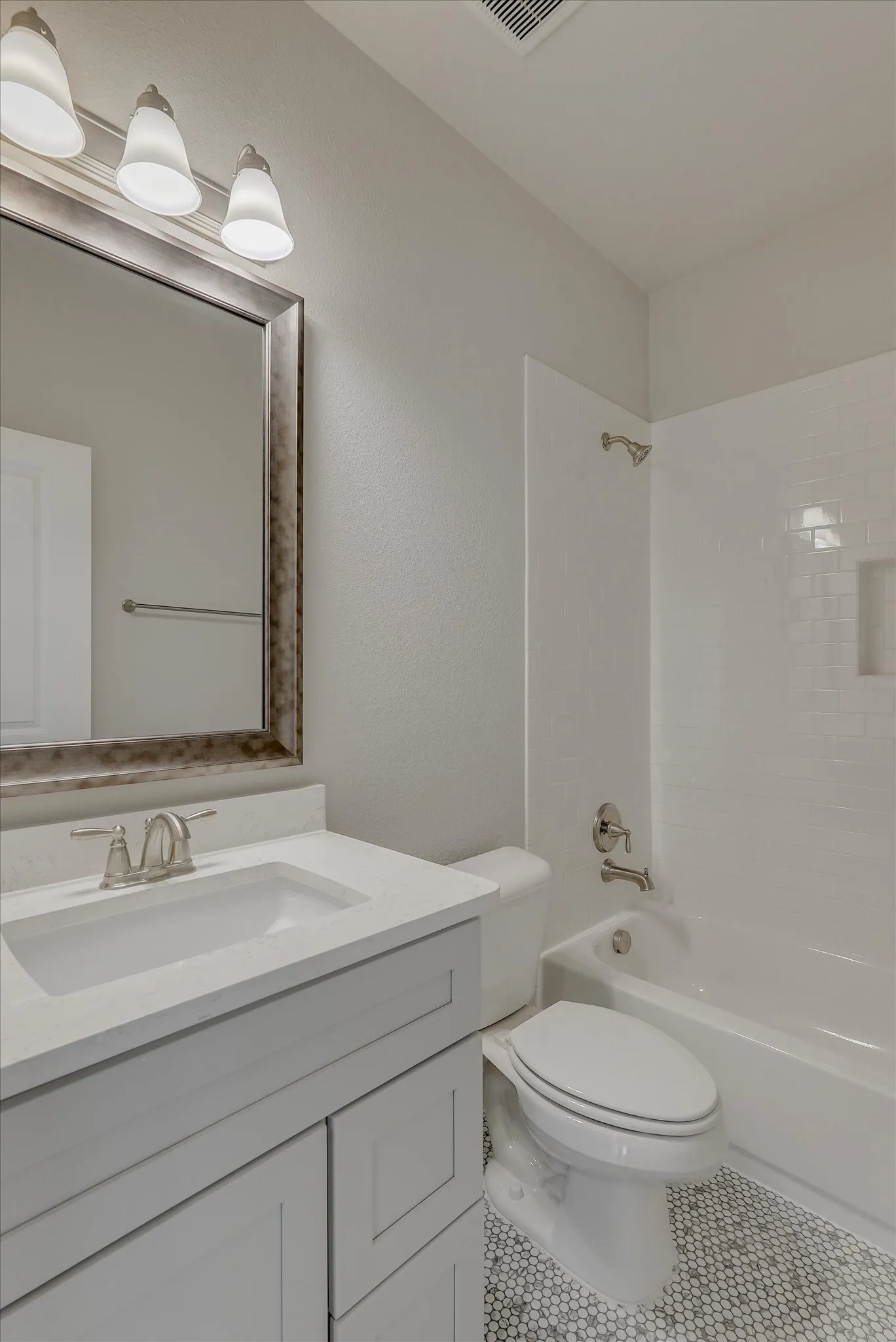Bathroom featuring a light-toned vanity with paneling, a white countertop, and a rectangular sink