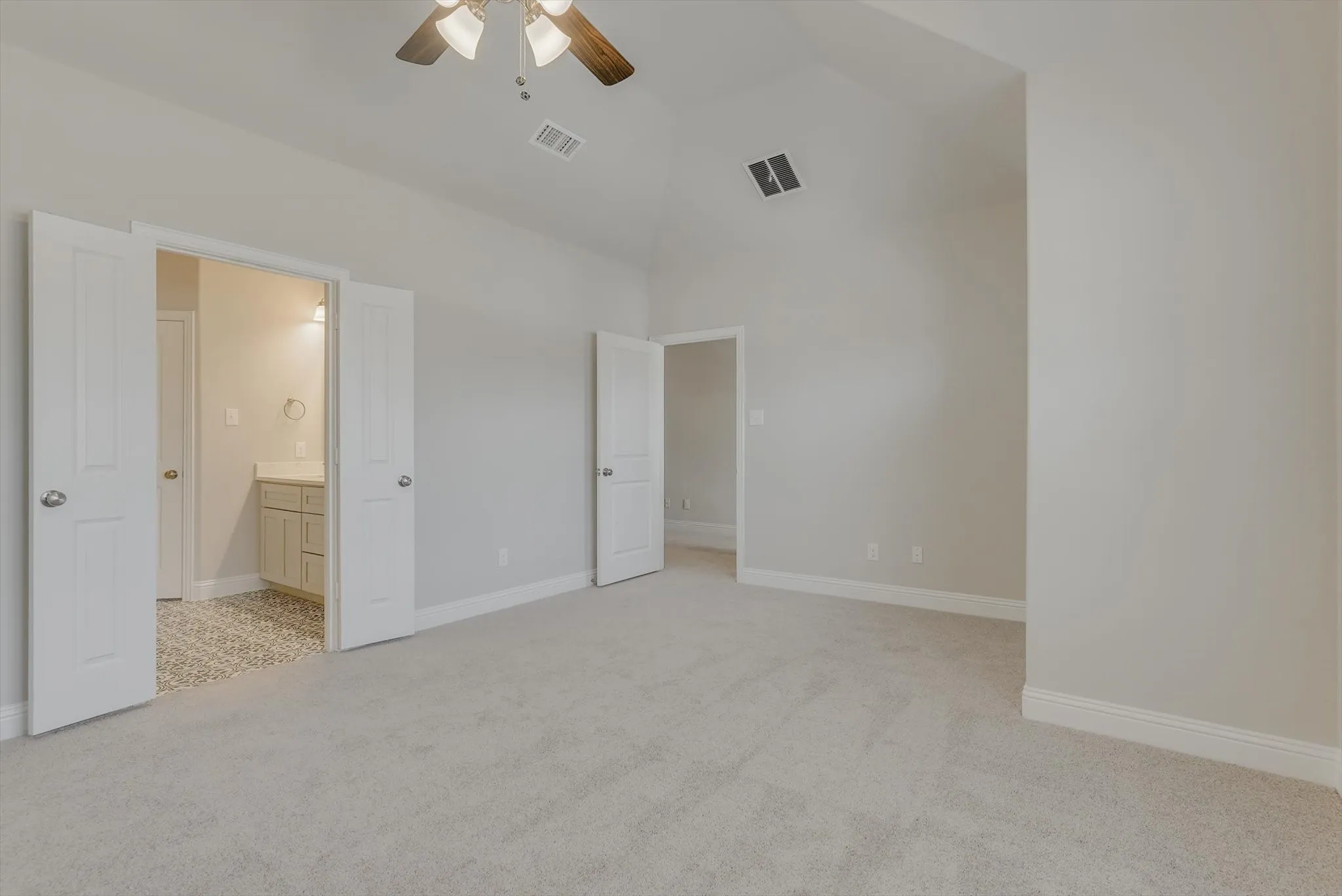 Vaulted ceiling, ceiling fan, plush carpeting, light gray walls, white trim