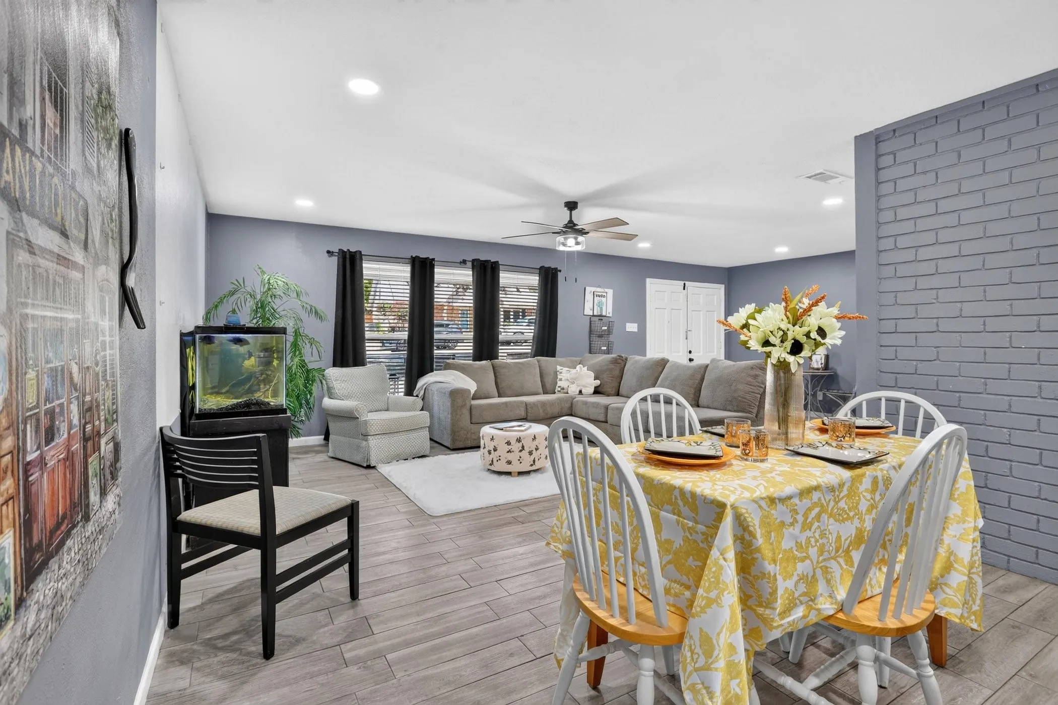 Open-concept living and dining area featuring wood-finish flooring, recessed ceiling lighting, and a ceiling fan