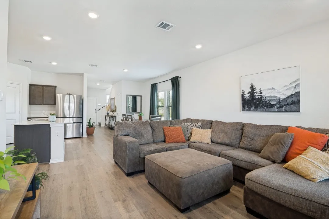 Recessed lighting, wood-finish flooring, white walls, and a kitchen island with built-in cabinetry