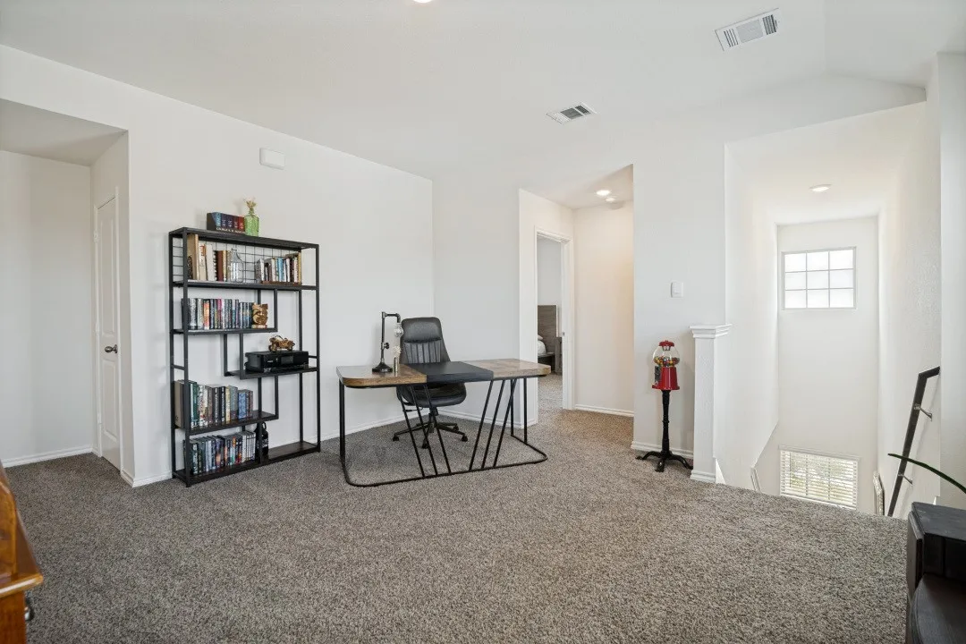 Carpeted area with white walls and recessed lighting