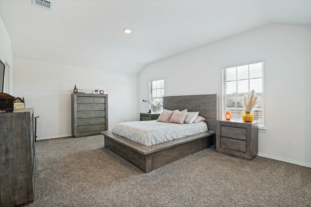 Carpeted room with vaulted ceiling and dual windows