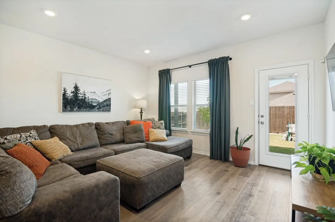 Wood-finish flooring, recessed lighting, and a glass-paneled door