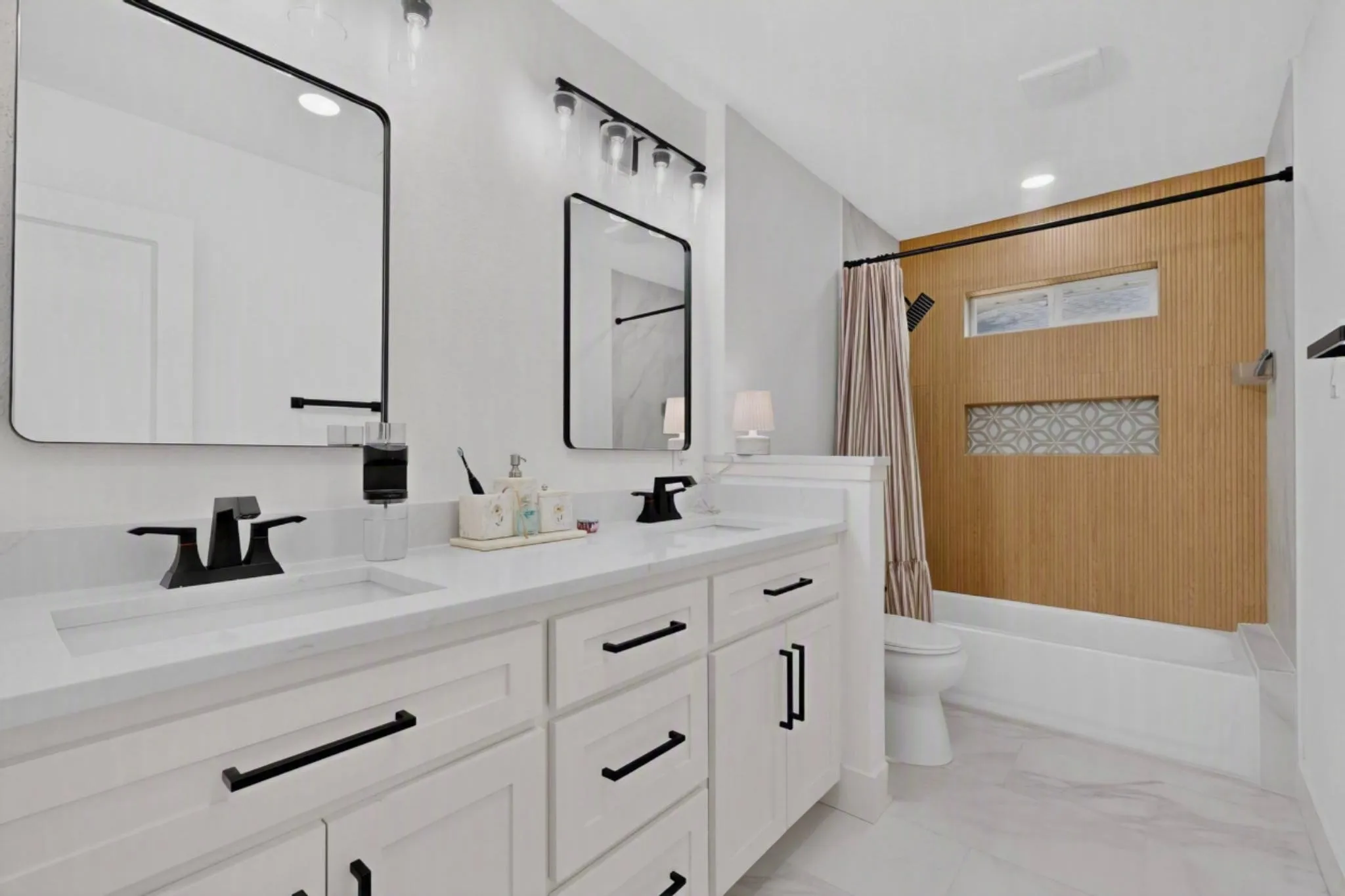 Dual vanity with integrated sinks, matte black fixtures, and white cabinetry