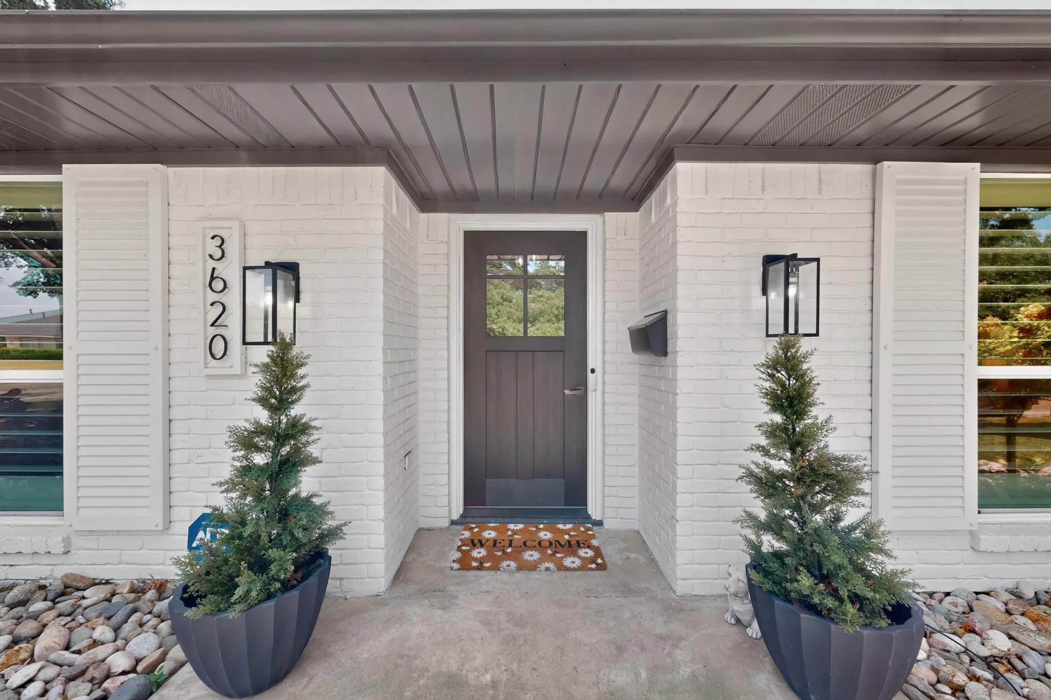 White brick exterior with dark wood-finish soffit