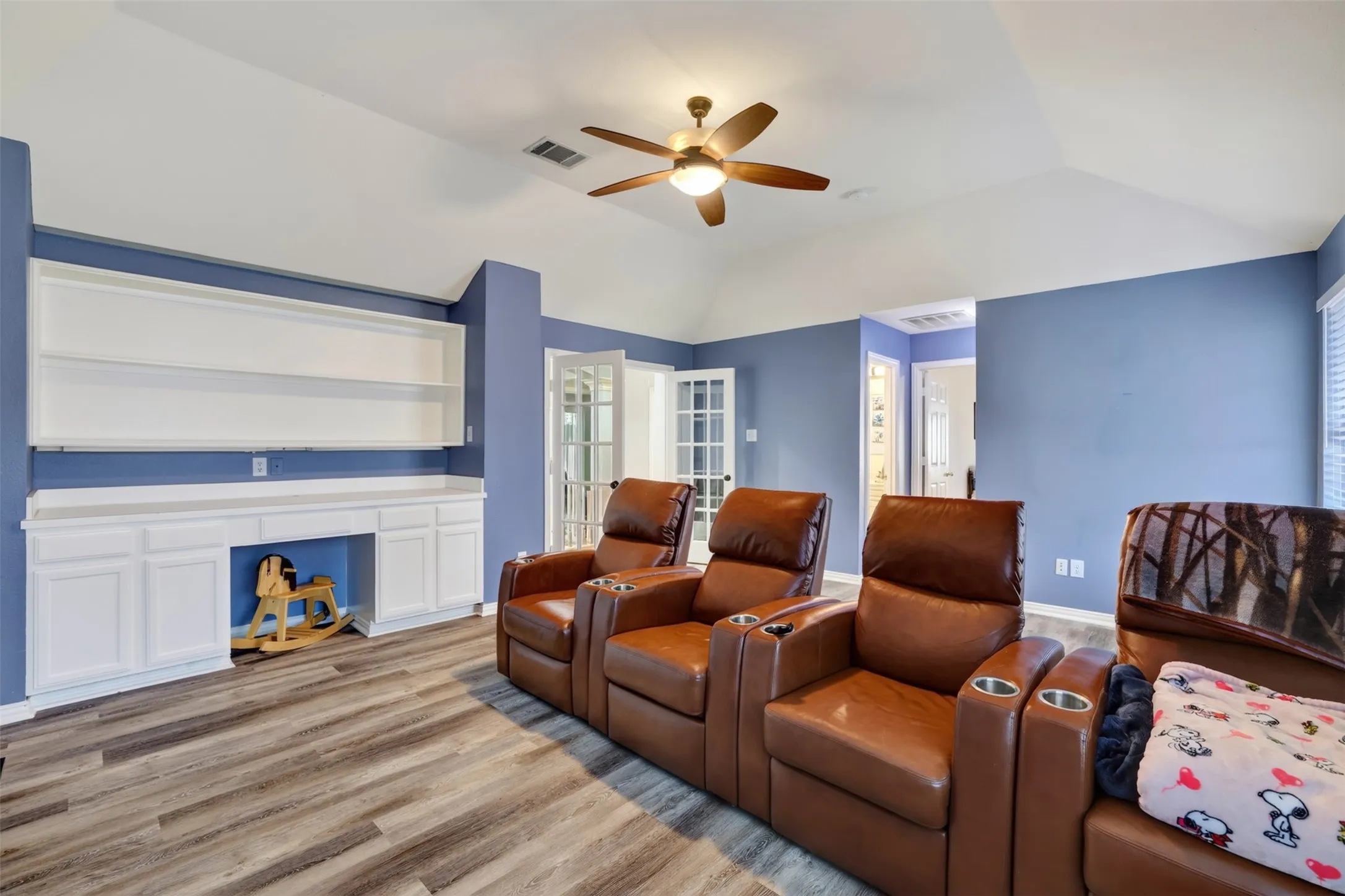 Game room or media room with built-in desk for homework with shelving and cabinets.