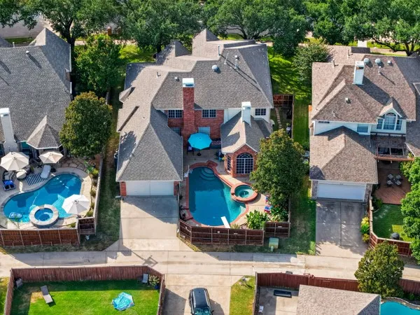 Aerial view showcasing the private backyard oasis with sparkling pool and spa, lush landscaping, and plenty of space for relaxing and entertaining.