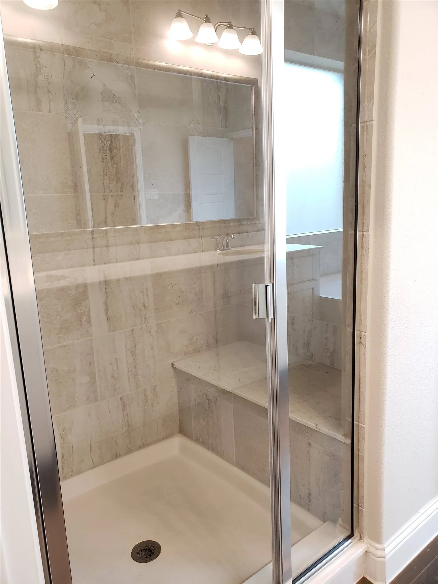 Primary Bath with Glass-enclosed shower with a built-in bench, tiled walls, and a shower pan