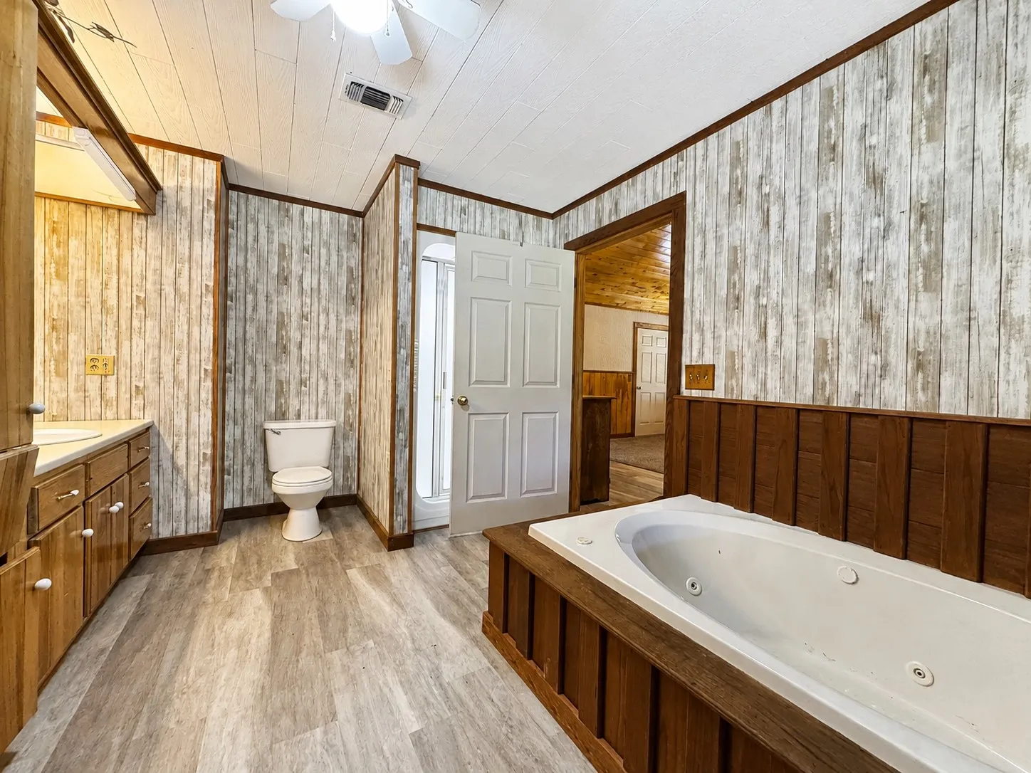 Vaulted wood-paneled ceiling with exposed beams and ceiling fans