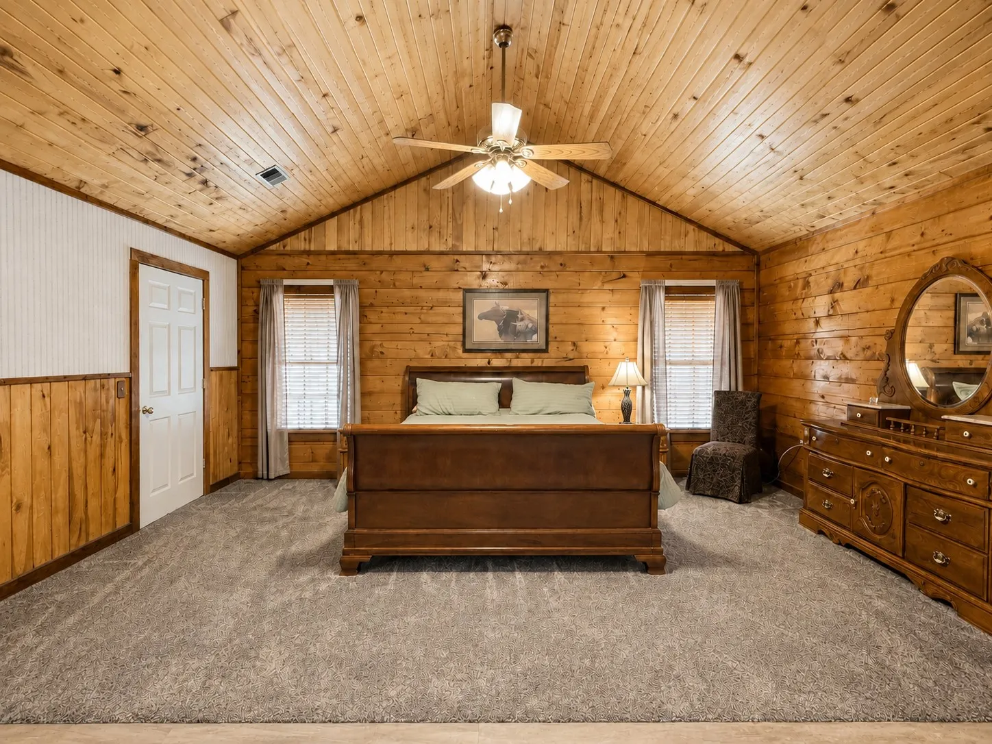 Spacious room featuring wood paneling, a vaulted wood-finish ceiling, and gray carpeting