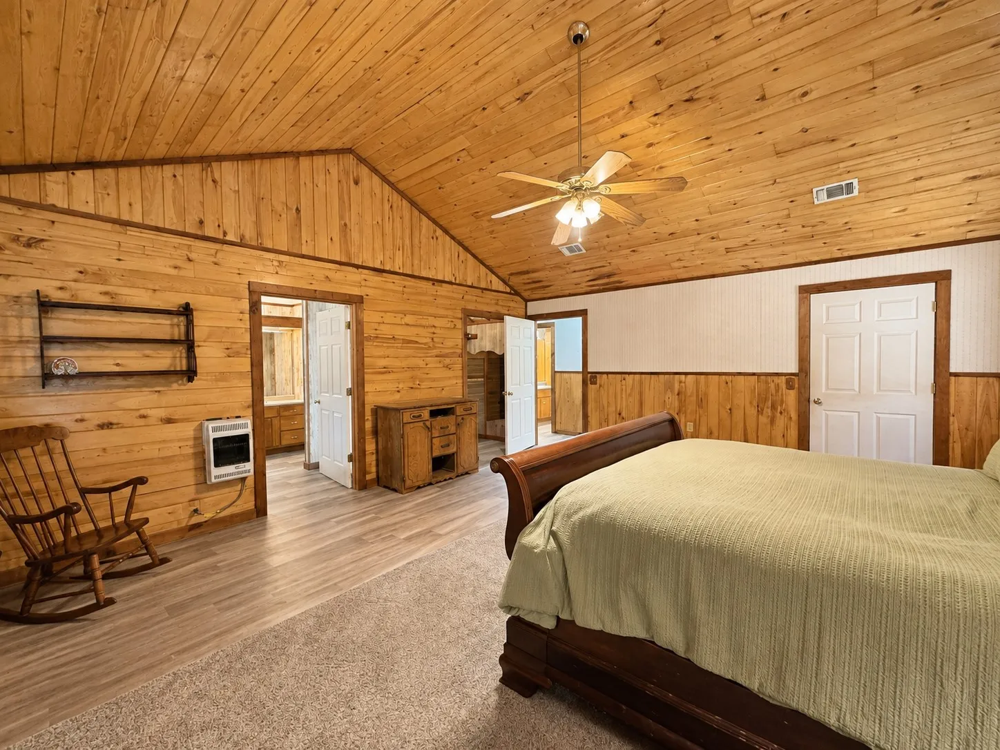 Vaulted wood-paneled ceiling with a central fan light fixture