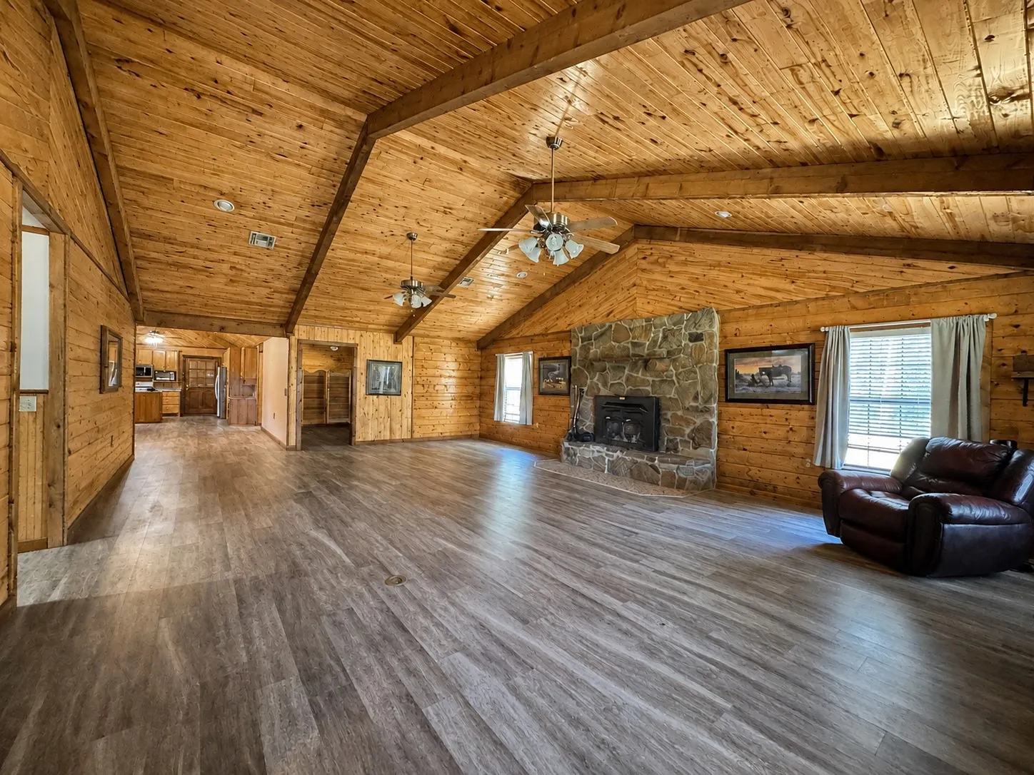 Spacious living area featuring wood-finish flooring and vaulted wood-paneled ceilings
