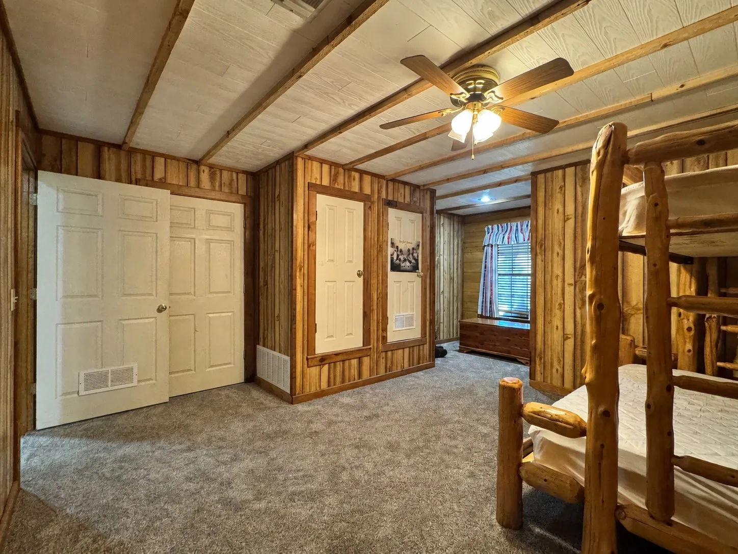 Interior room featuring wood paneling, textured ceiling, and gray carpet flooring