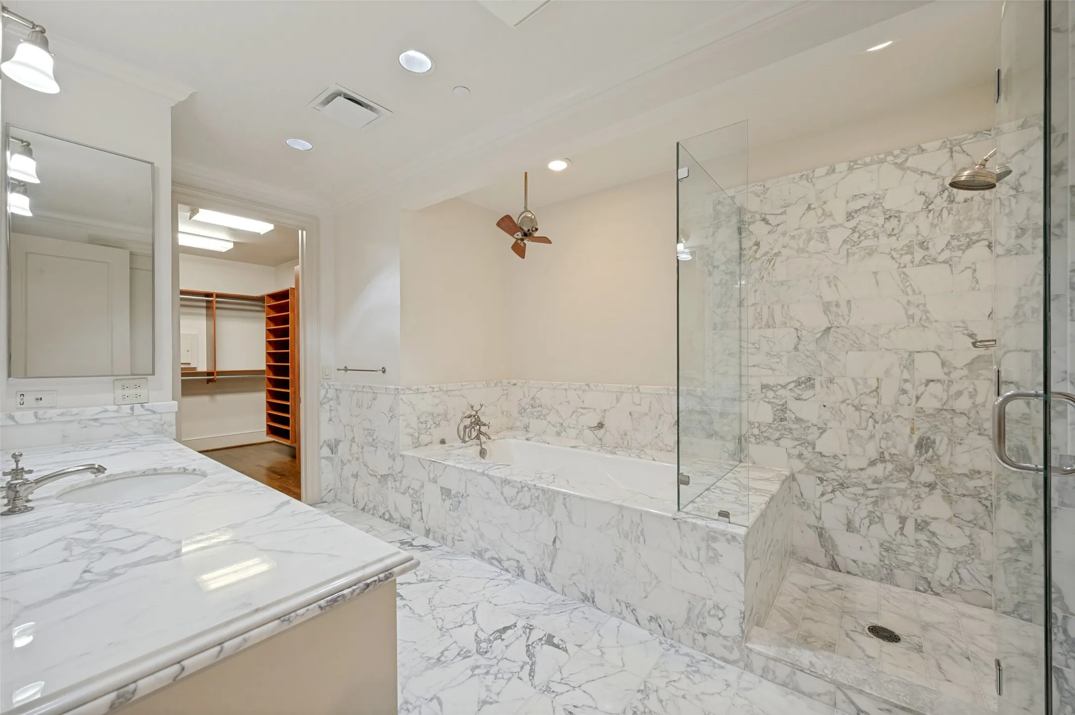 View of first bath in primary bedroom past shower and jetted tub to closet