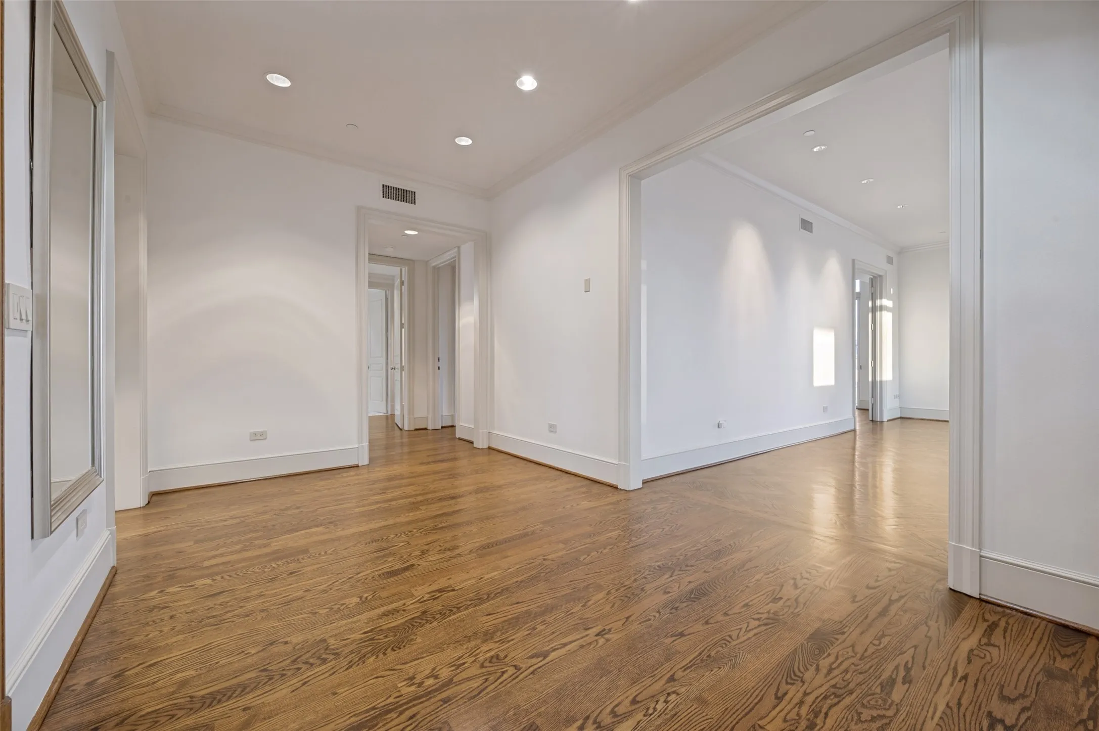 View from front door into living room and through foyer toward primary suite and second bedroom doorways.