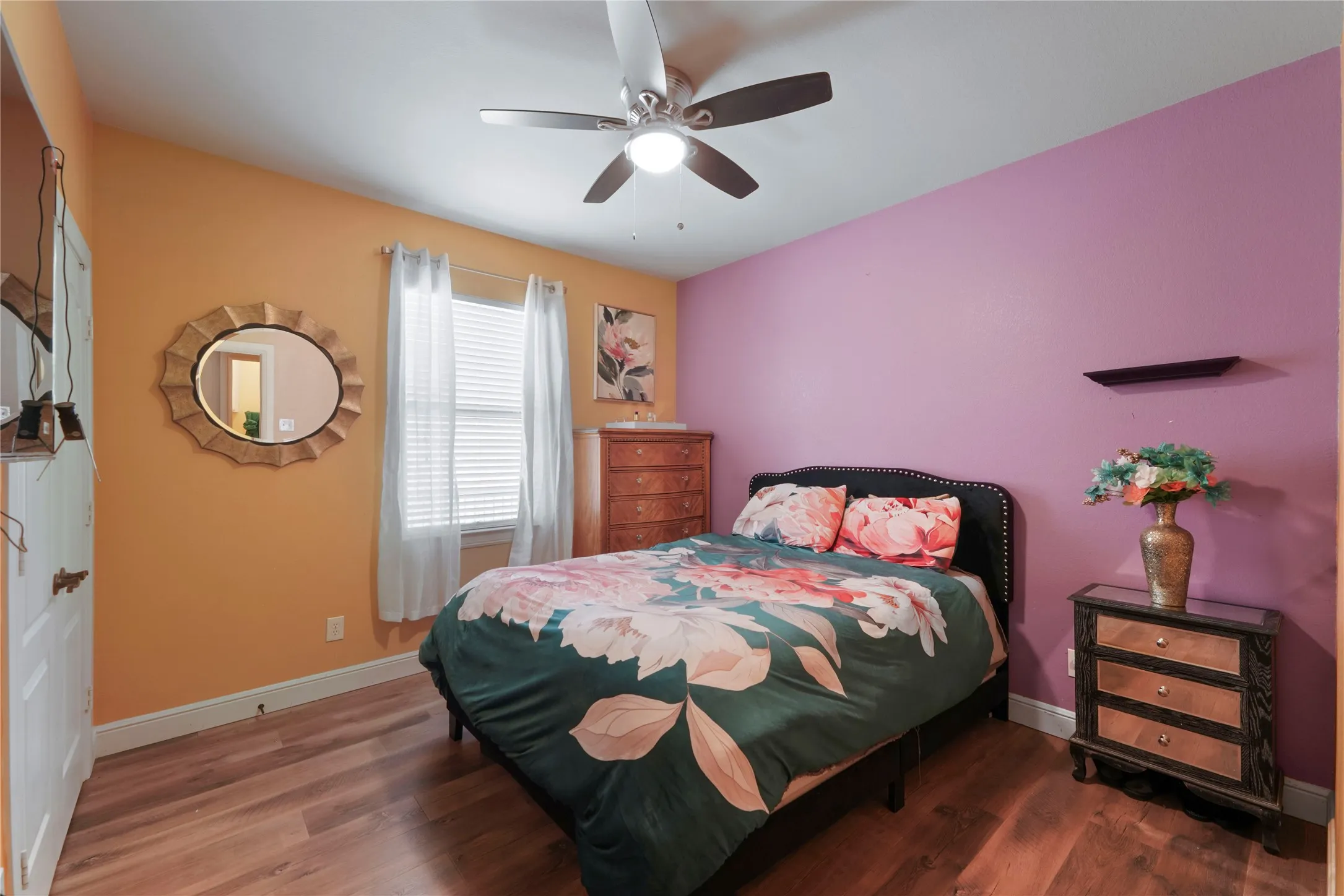 Wood-finish flooring, ceiling fan with integrated lighting, and a window with blinds