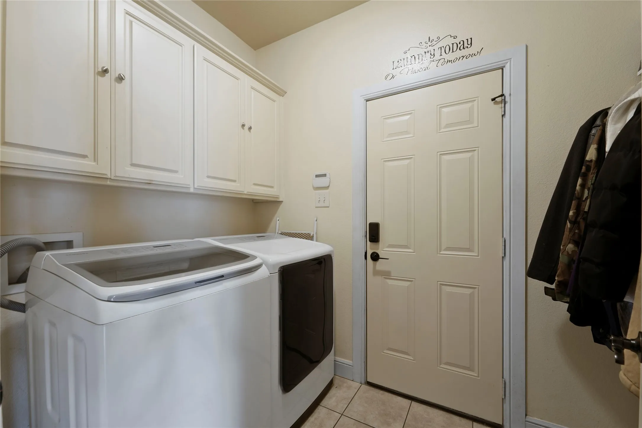 Built-in cabinetry with crown molding, tiled flooring, and a paneled door