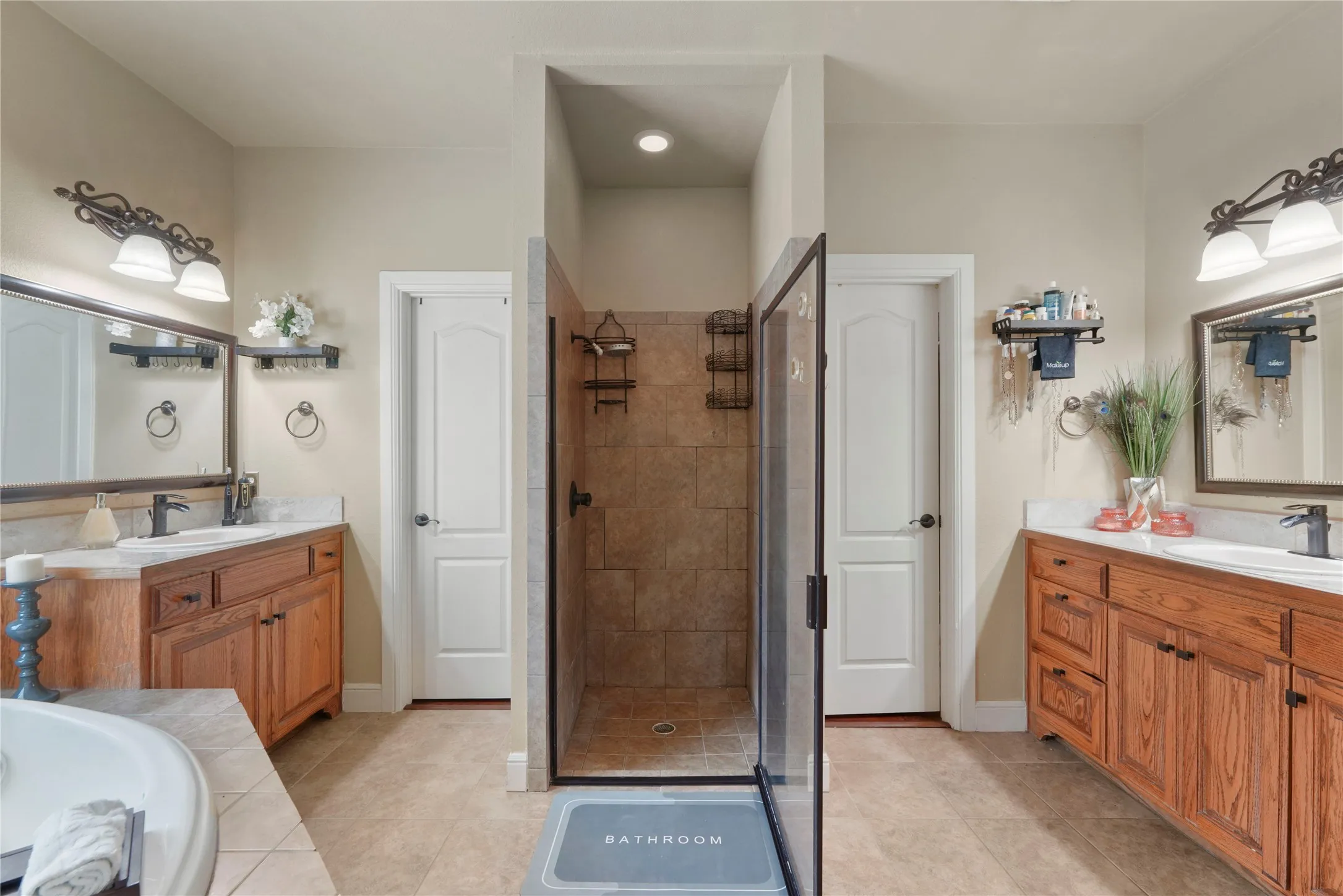 Dual wood-finish vanities with undermount sinks and dark hardware