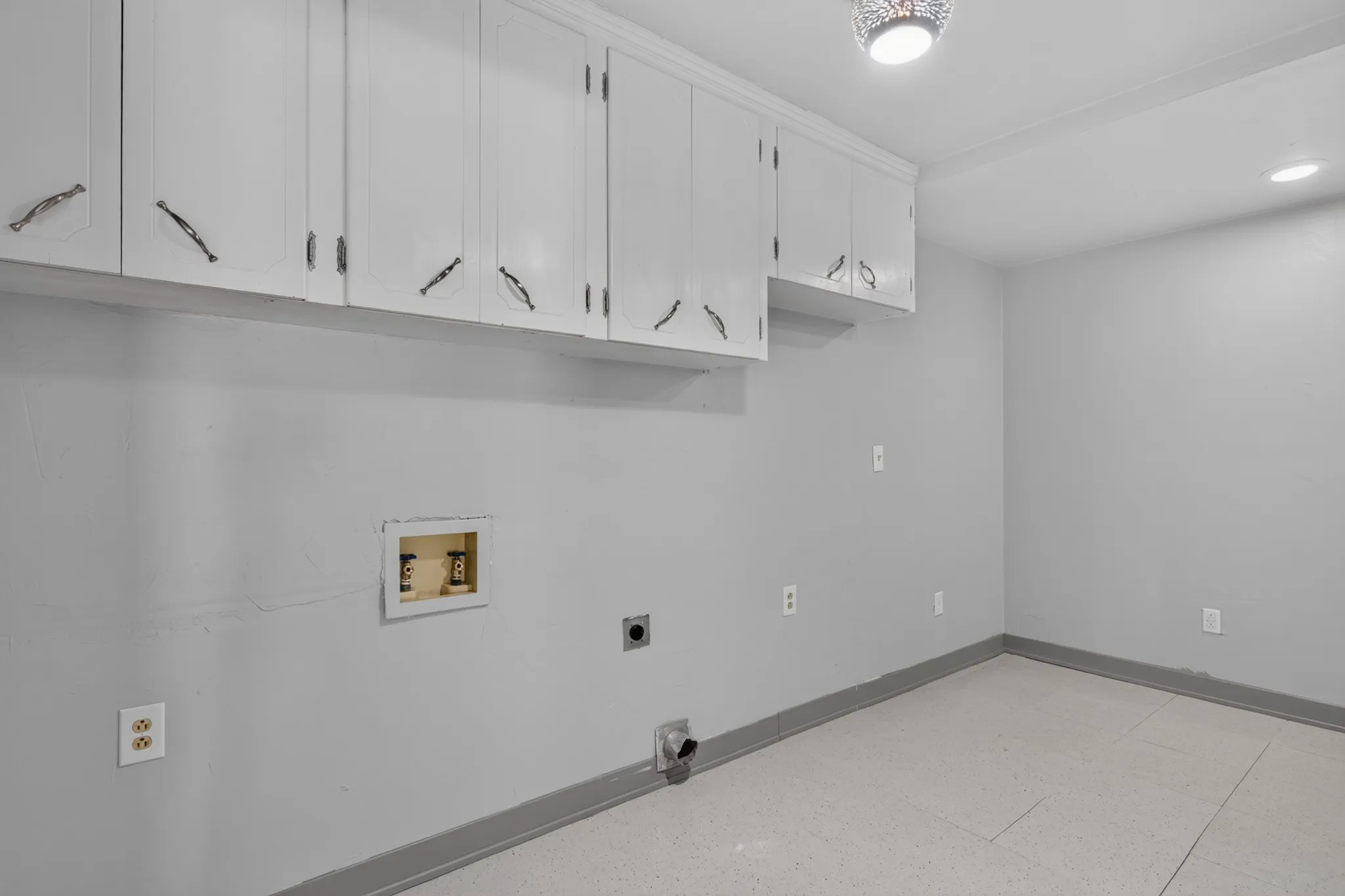 The oversized laundry room features abundant built-in cabinetry and the two-car garage offers overhead storage and an exterior access door for added convenience.