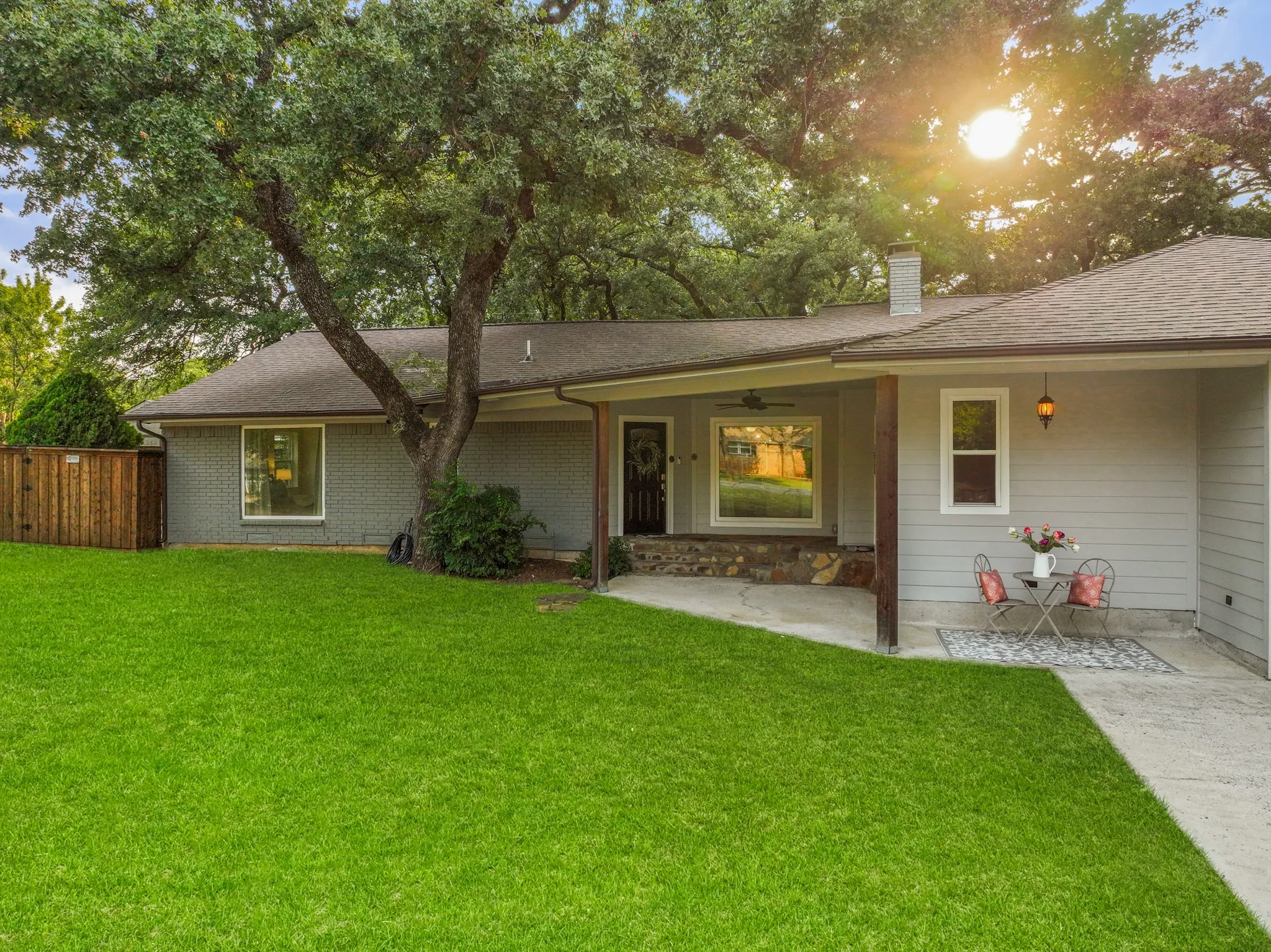 From the charming stone covered front porch to the inviting double entry doors, you are led into a beautiful space that features hardwood floors, vinyl windows, crown molding and abundant natural light. The spacious living room centers around a painted wood burning brick fireplace and custom built-ins that bring warmth and function. Grass color in this photo has been enhanced.