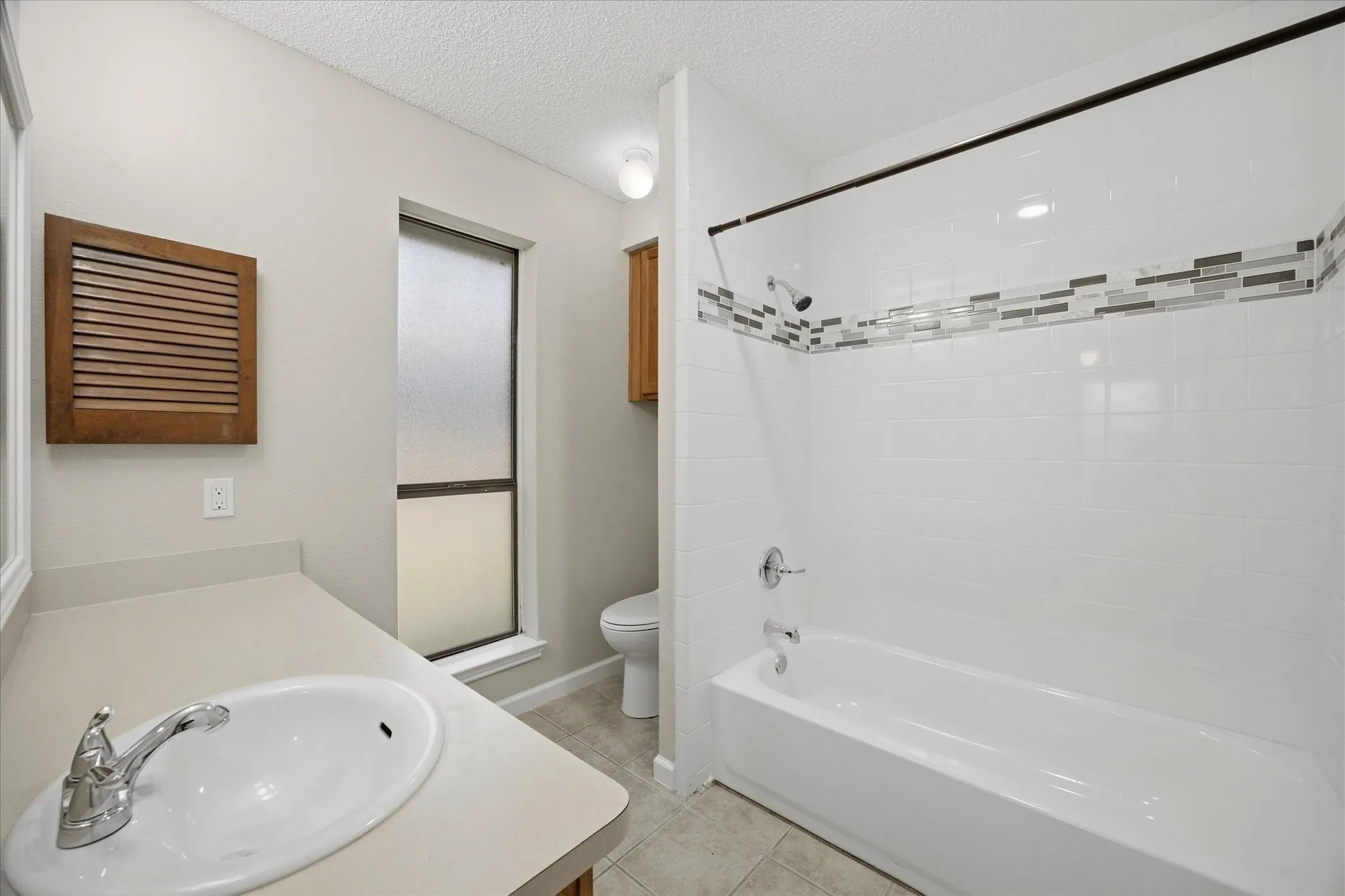 White subway tile bath surround with decorative accent band