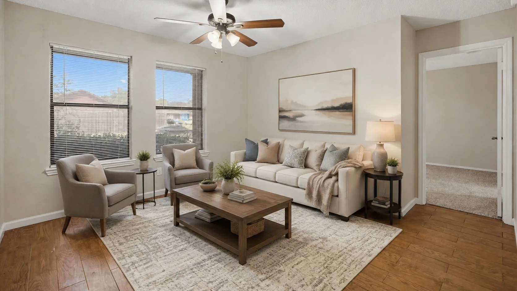 Wood-finish flooring, ceiling fan with integrated lighting, two double-hung windows, and light neutral wall colors