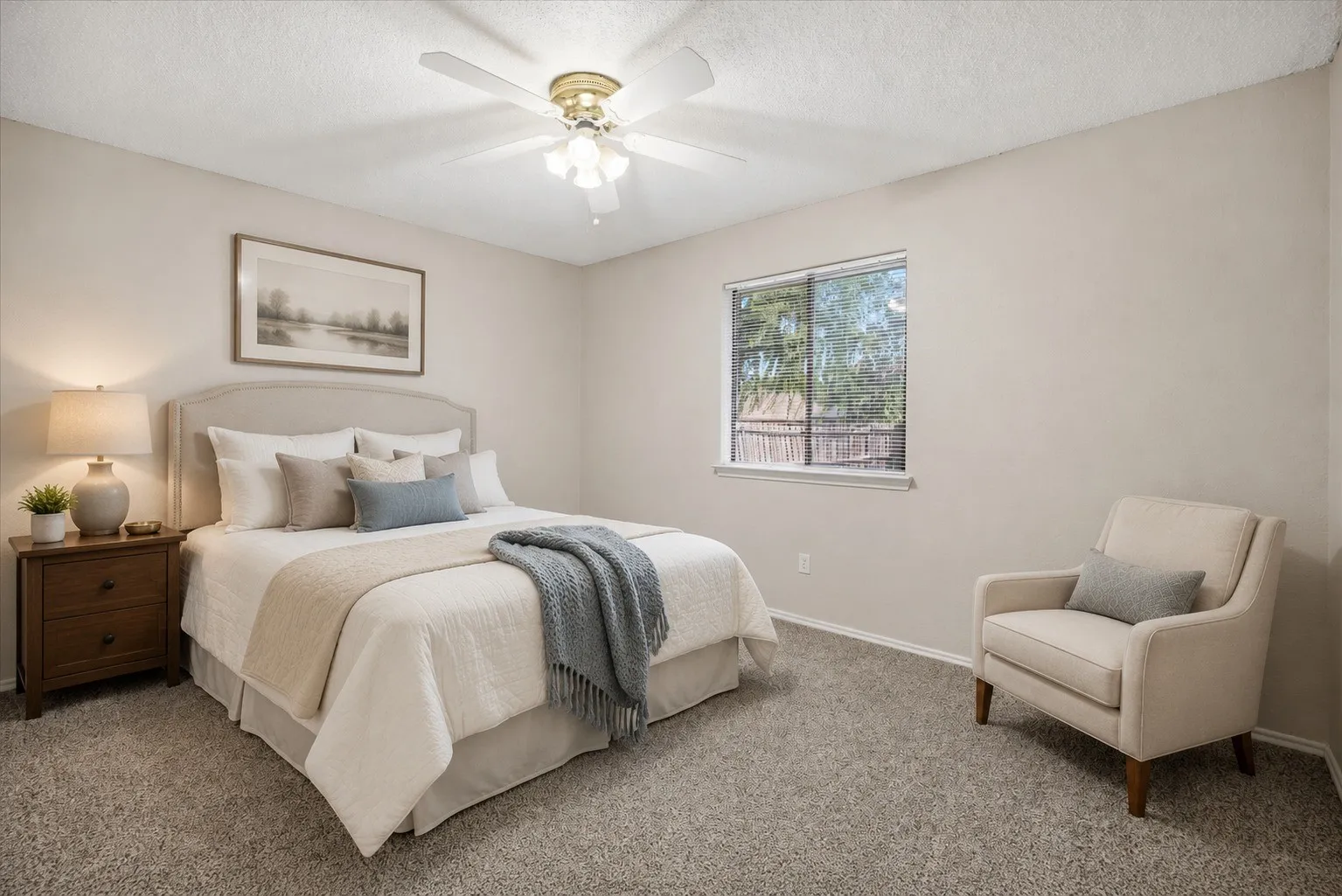 Wall-to-wall carpeting, ceiling fan with light fixture, window with outdoor scenery, and neutral wall paint