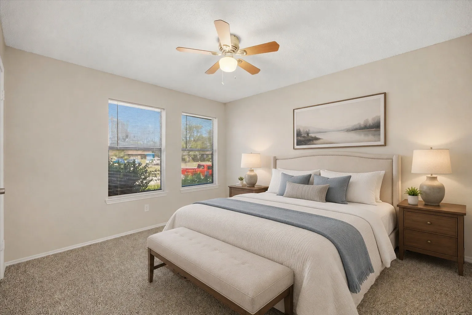 Carpeted flooring, two windows with blinds, and a ceiling fan with integrated lighting