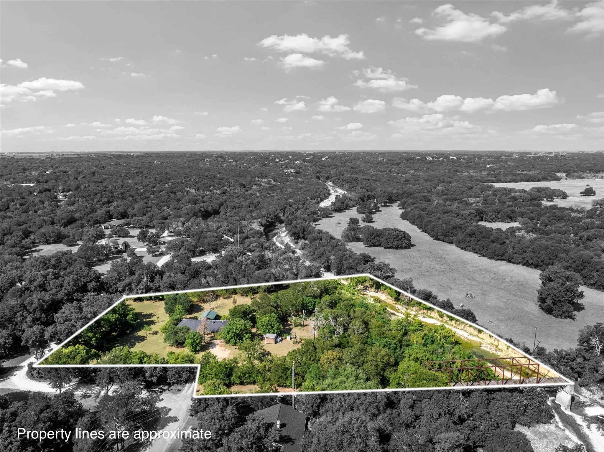 Expansive property with a verdant landscape, featuring a large, irregularly shaped lot, mature trees, and a residential structure