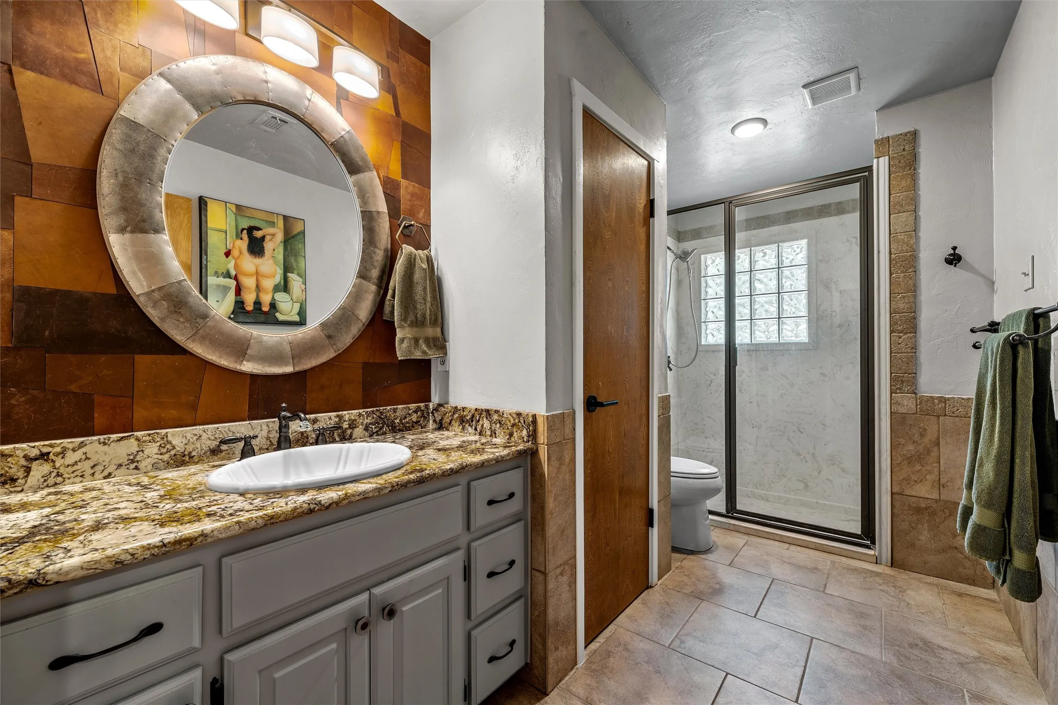 Vanity with granite countertop, integrated sink, and gray cabinetry