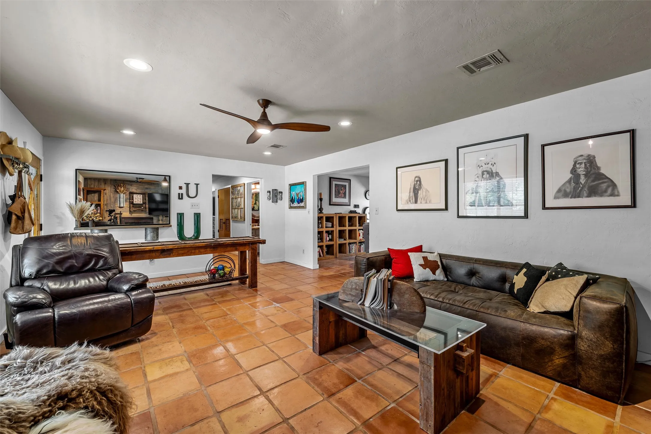 Spacious room featuring square terracotta-style floor tiles, a ceiling fan, and recessed lighting