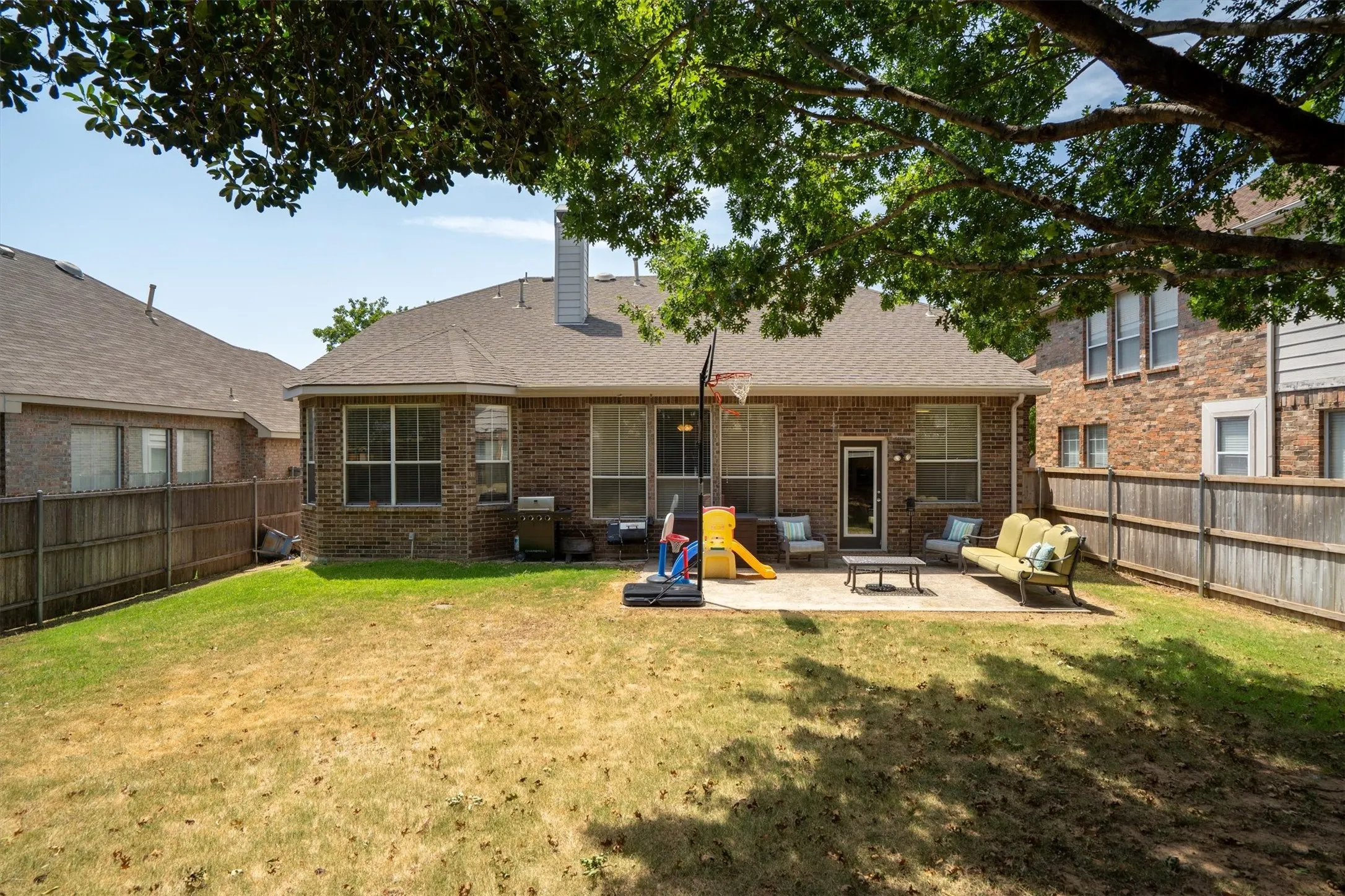 Brick exterior with multiple windows and a rear entry door
