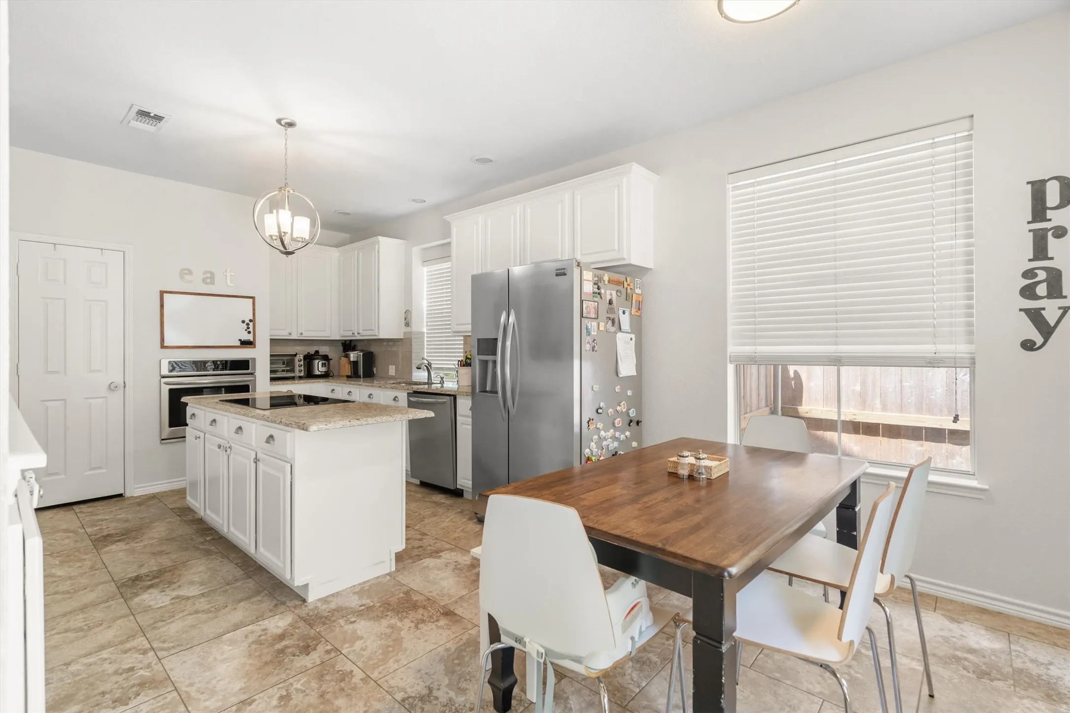 Kitchen featuring a central island with countertop, ample white cabinetry, stainless steel appliances, and tile flooring
