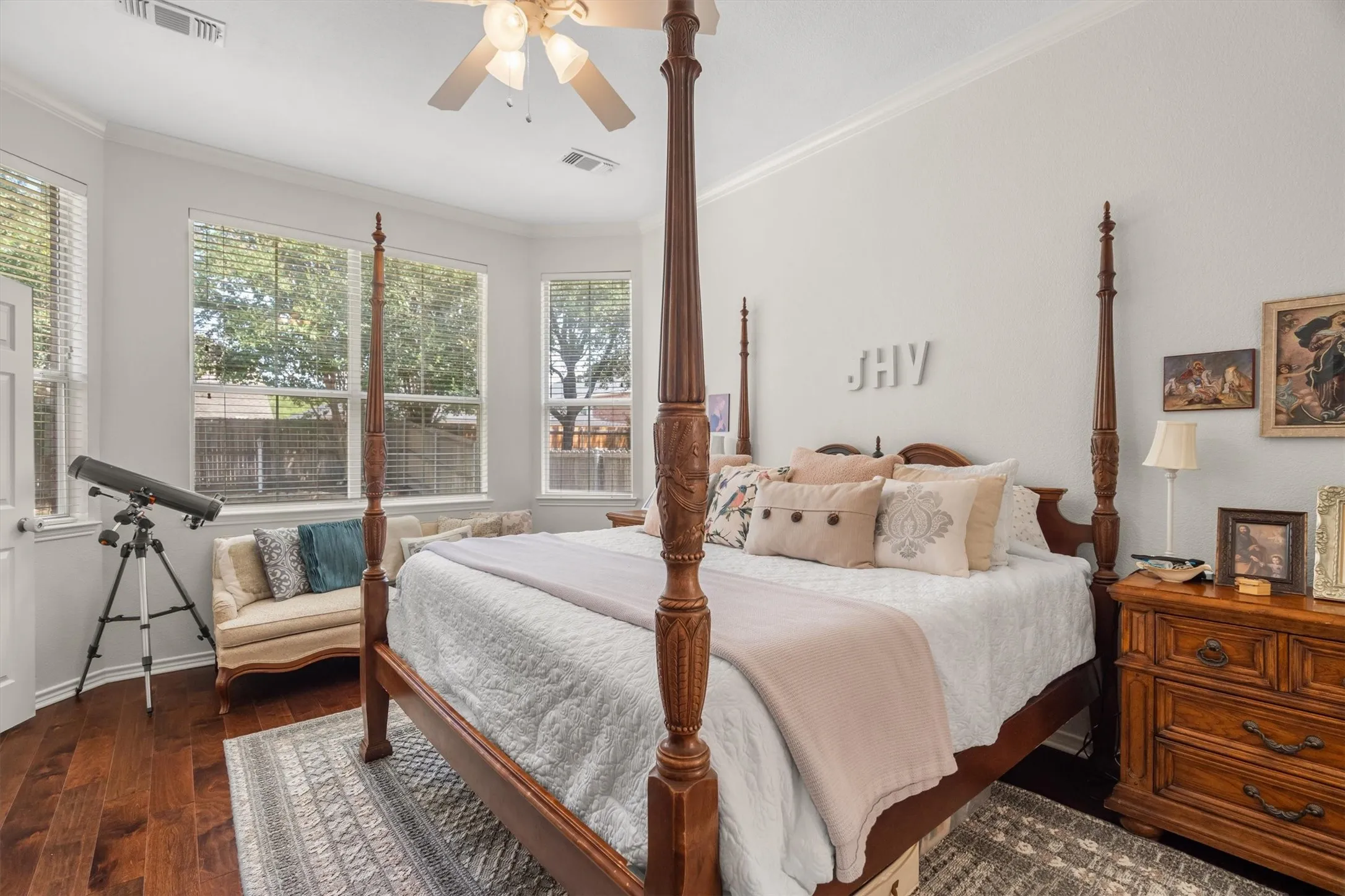 Hardwood flooring, bay window with multiple panes, ceiling fan, and crown molding