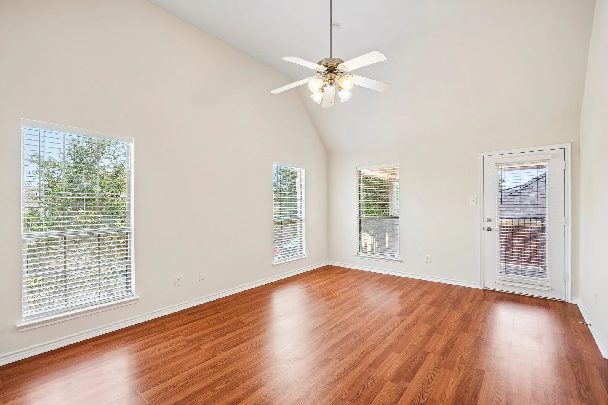 Bright and inviting bedroom featuring beautiful hardwood floors, soaring ceilings, and abundant natural light.Leads to covered balcony for your enjoyment