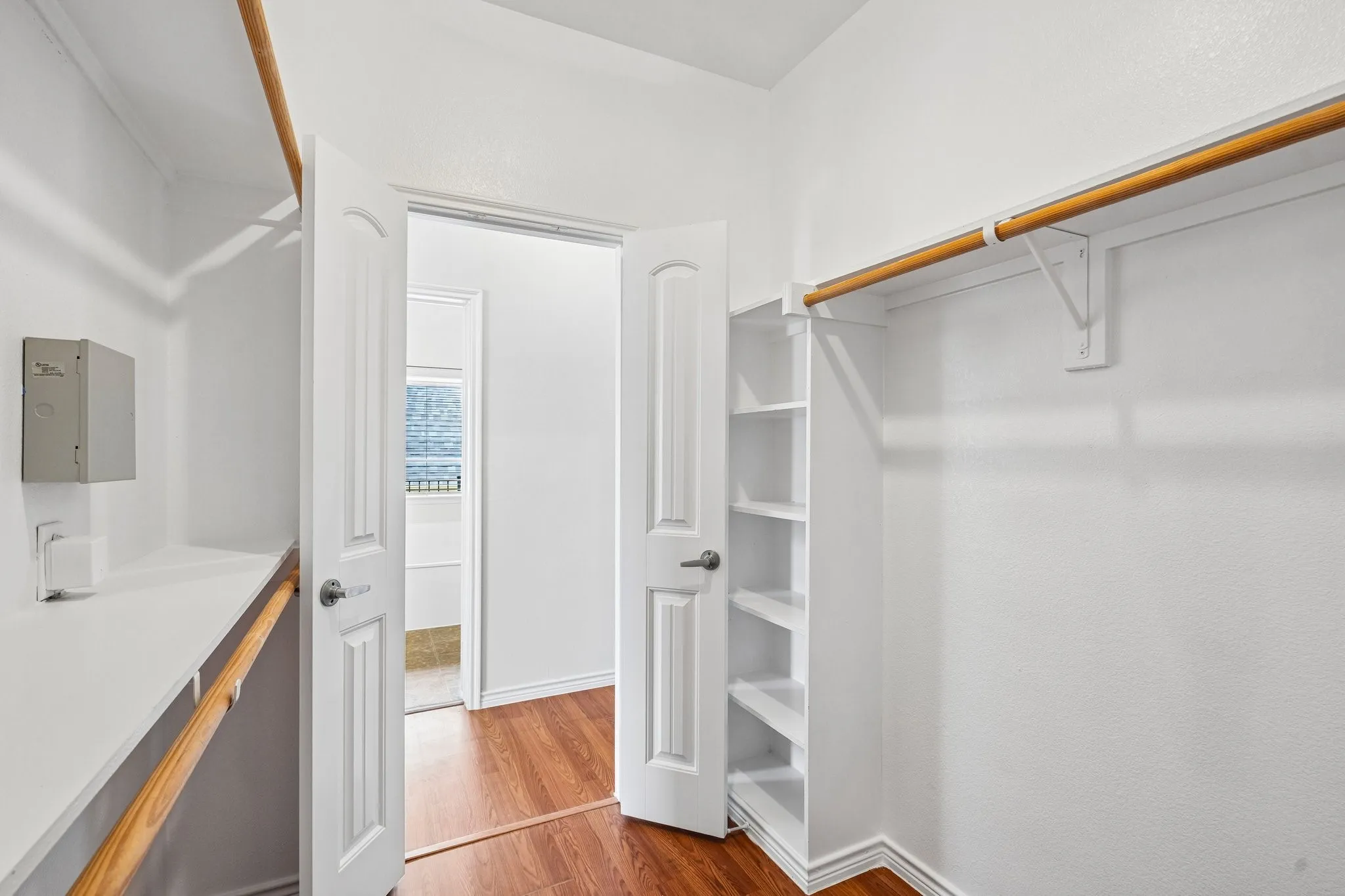 Generously sized walk-in closet featuring ample hanging space, built-in shelving, and convenient access from the primary suite