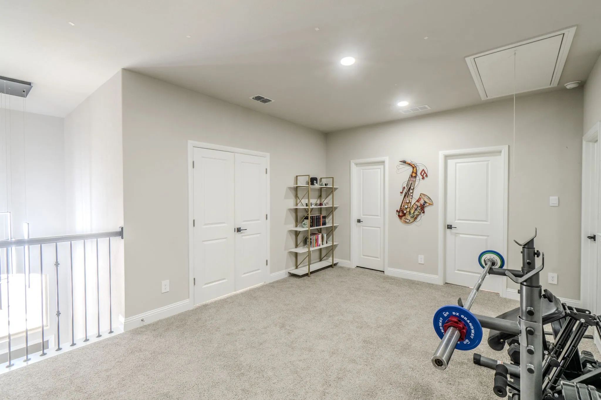 Carpeted loft area featuring recessed lighting and multiple panel doors