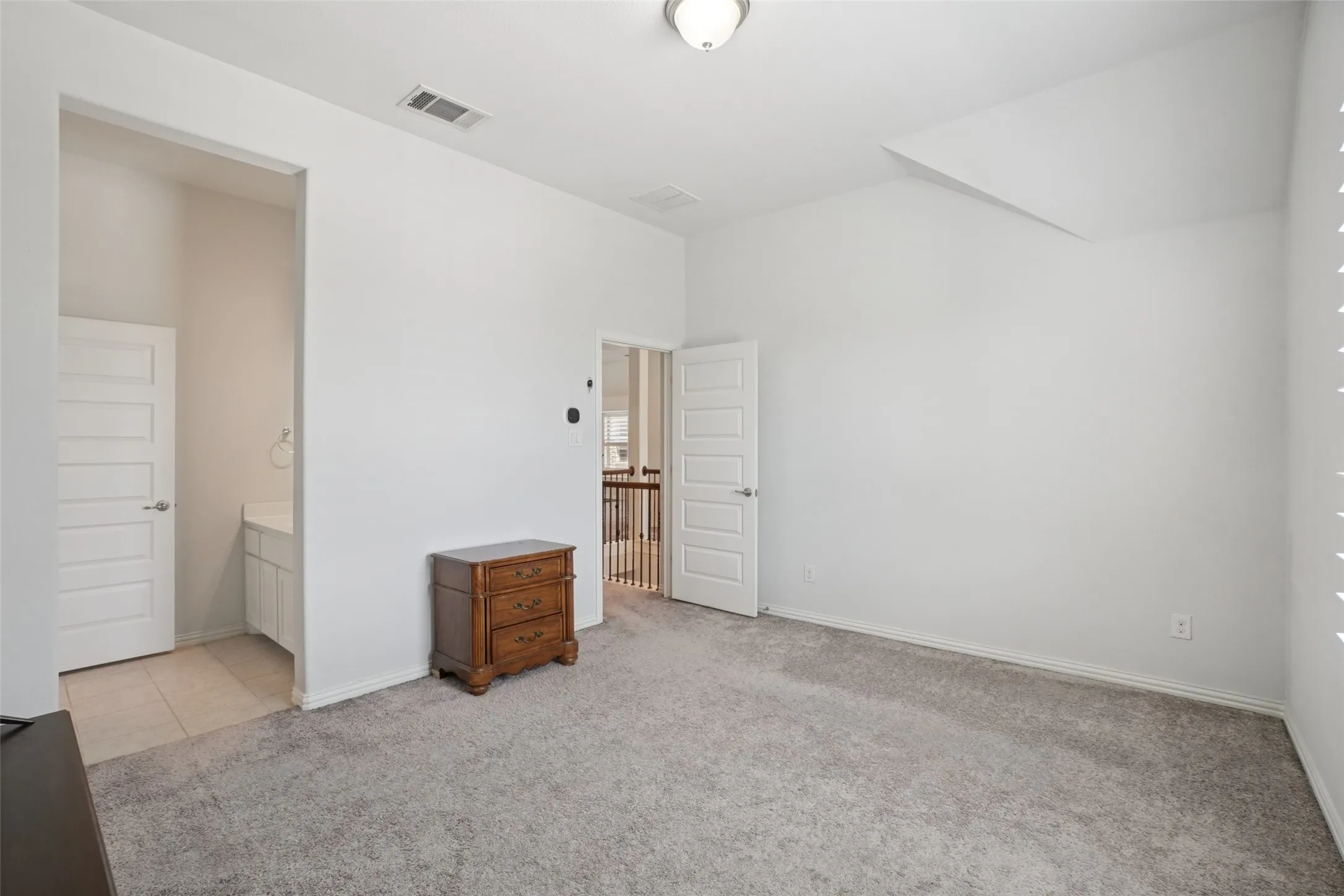 Unfurnished bedroom with carpet flooring, lofted ceiling, and connected bathroom