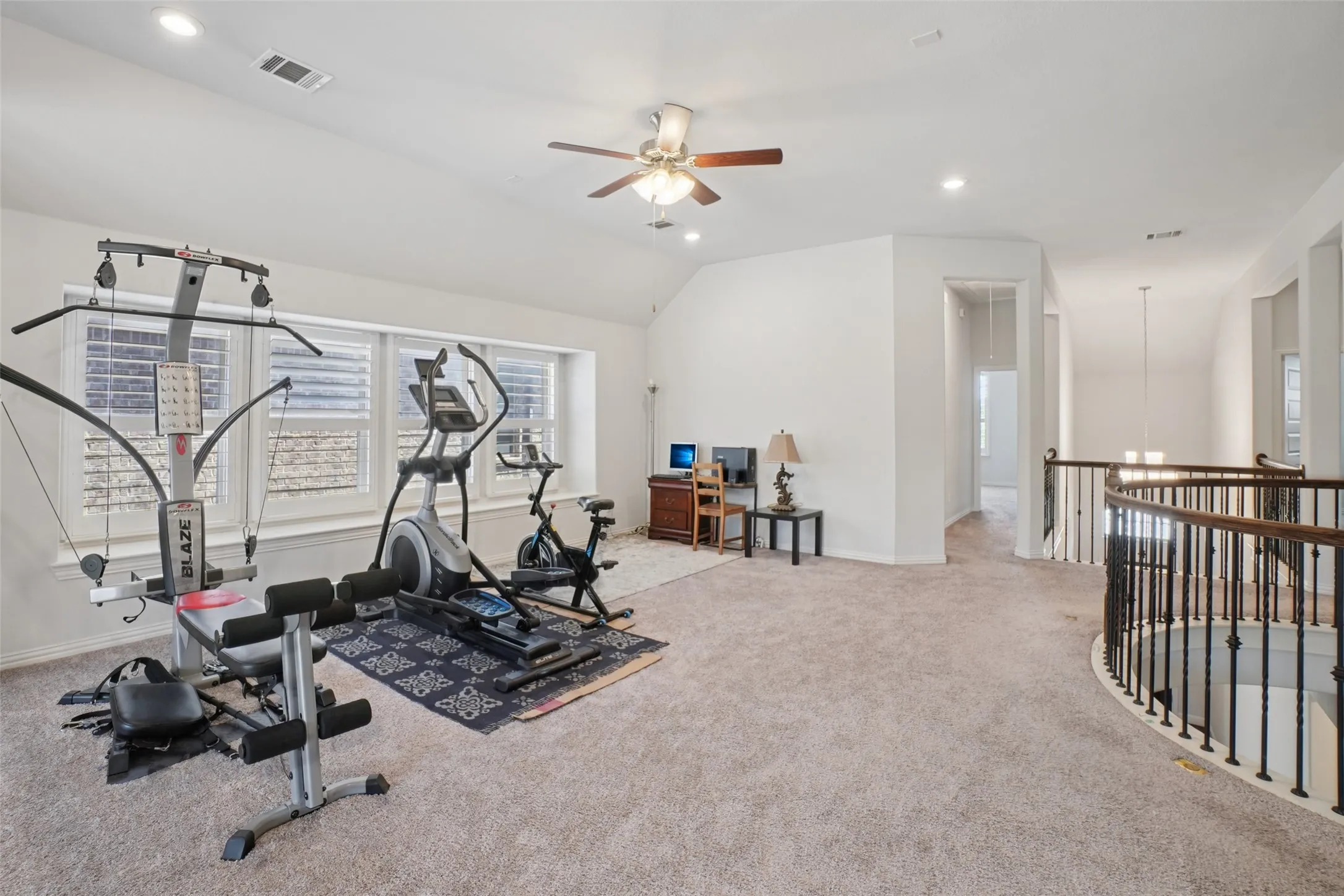 Exercise room with carpet flooring, ceiling fan, lofted ceiling, a chandelier, and recessed lighting