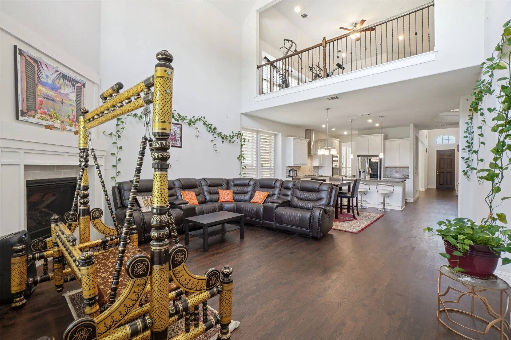 Living area featuring a high ceiling, a fireplace, and dark wood-type flooring