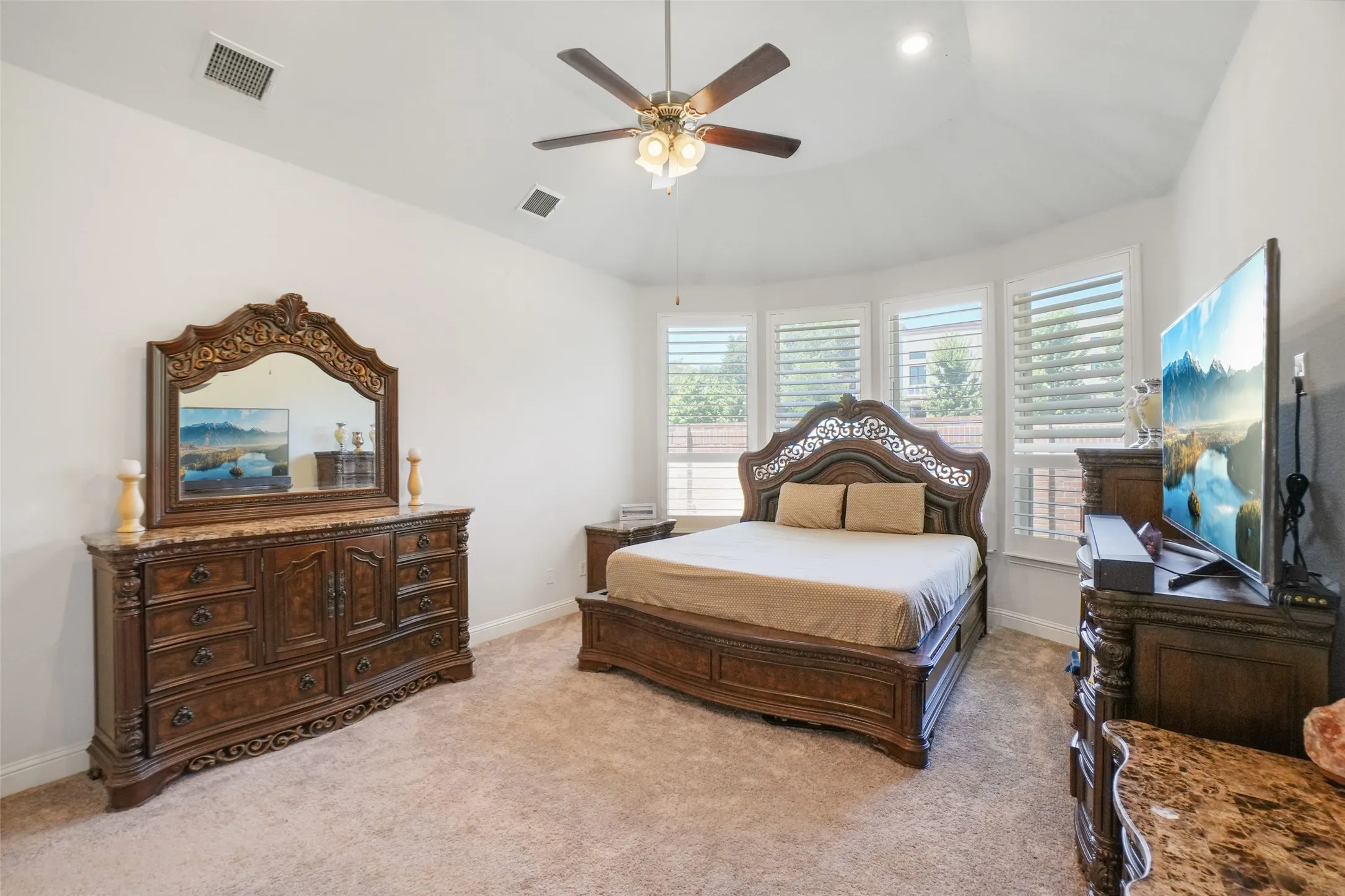 Bedroom with light colored carpet and a ceiling fan