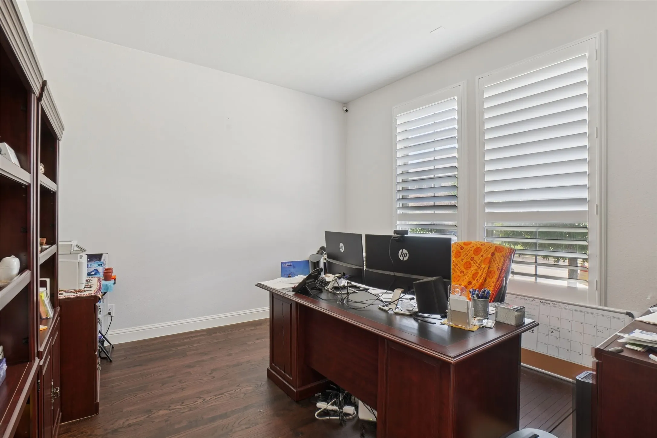 Office area with dark wood-type flooring and baseboards