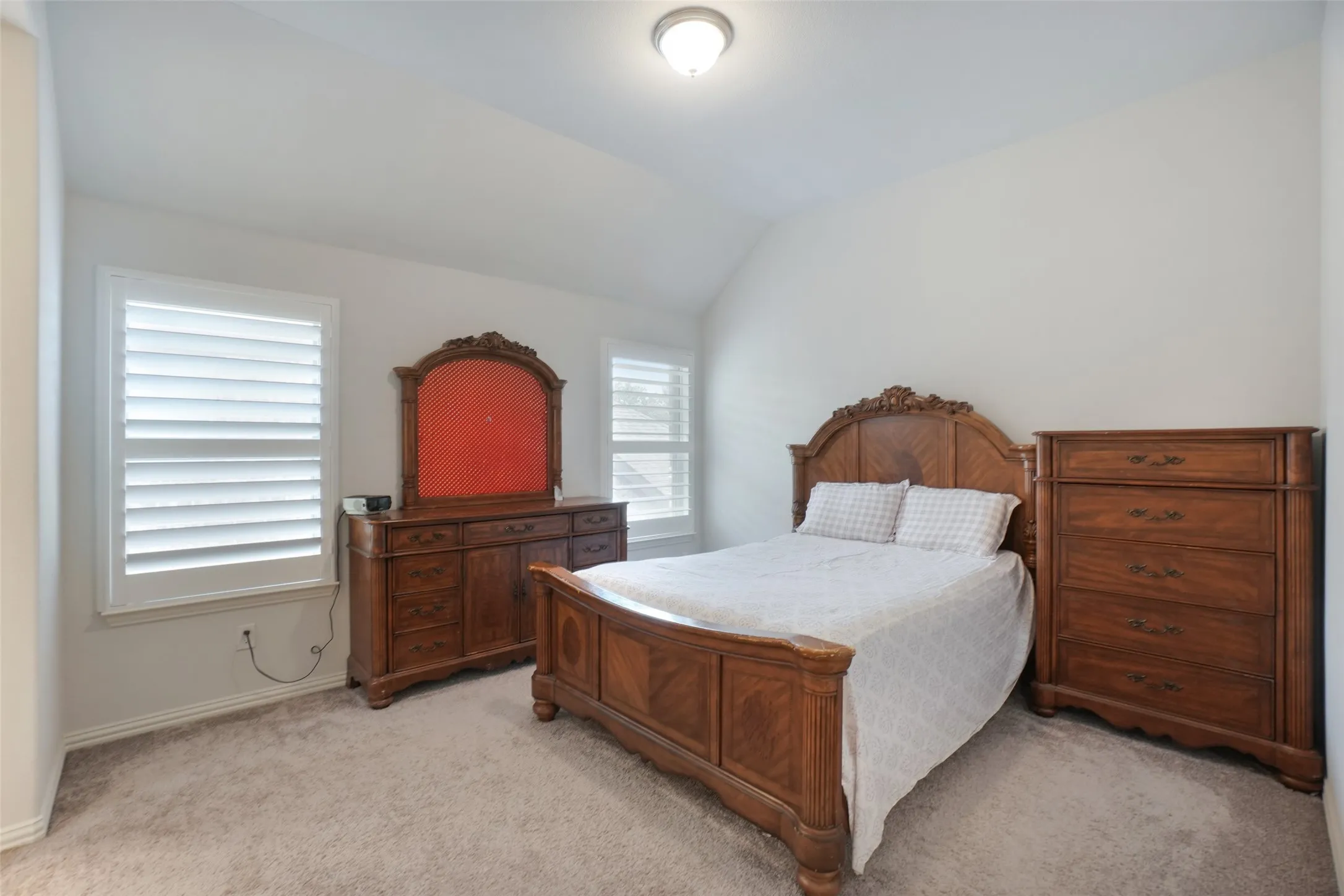 Bedroom featuring light carpet and lofted ceiling