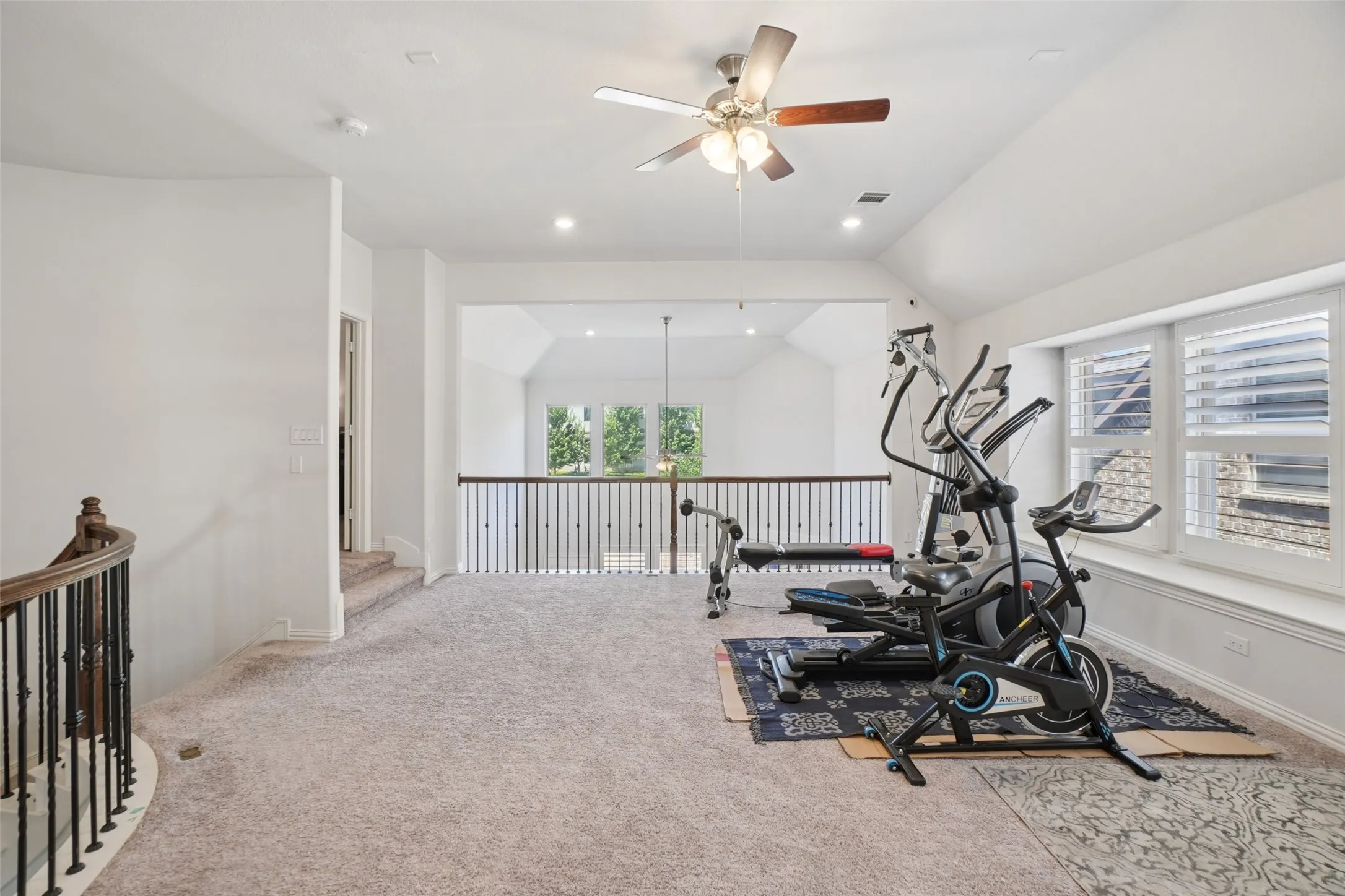 Exercise room with ceiling fan, carpet, lofted ceiling, and recessed lighting