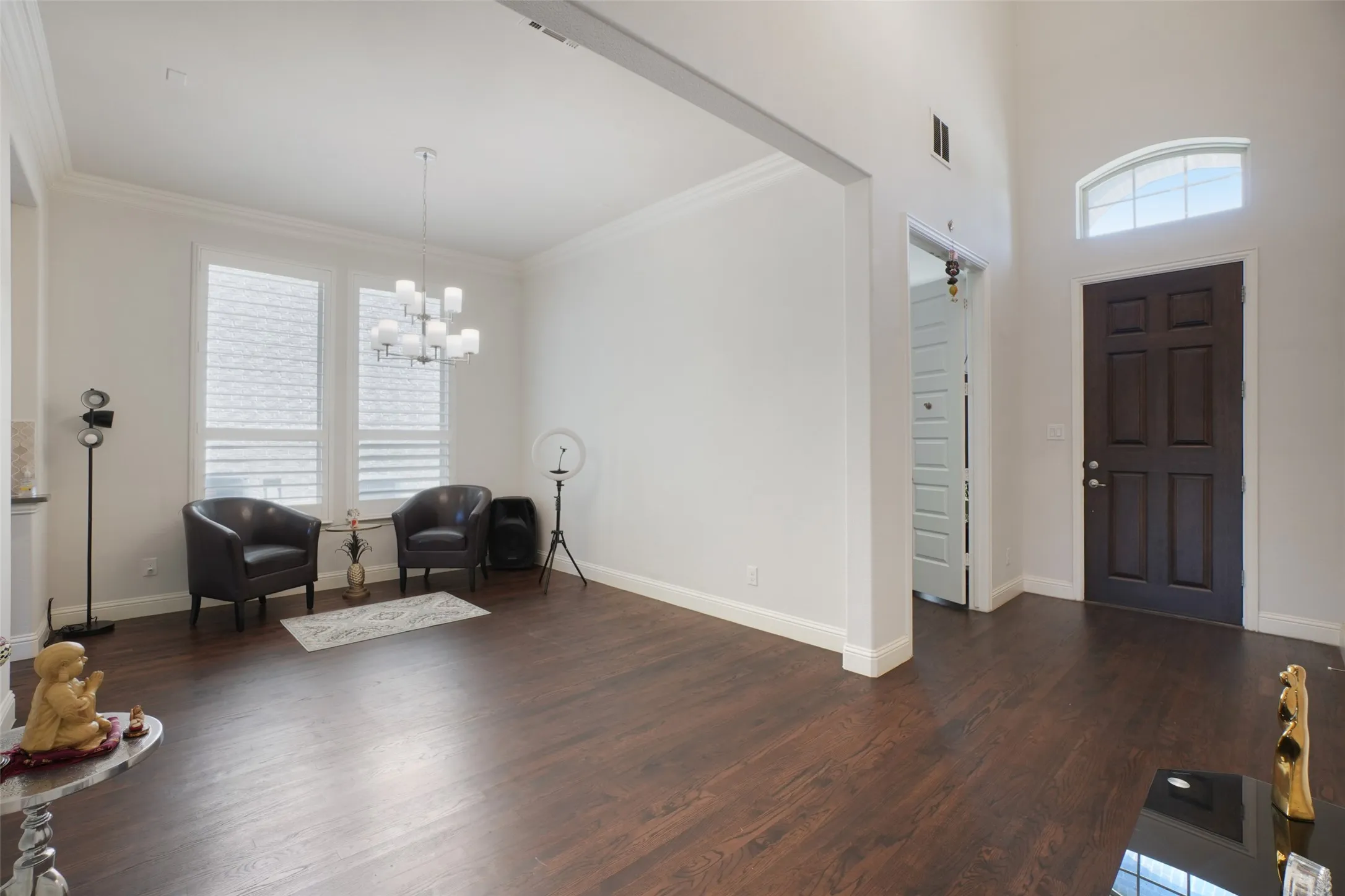 Entrance foyer featuring a chandelier, dark wood finished floors, and ornamental molding