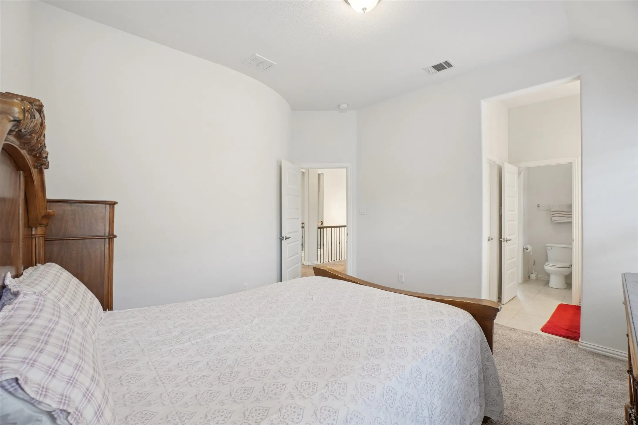 Carpeted bedroom with lofted ceiling and ensuite bath