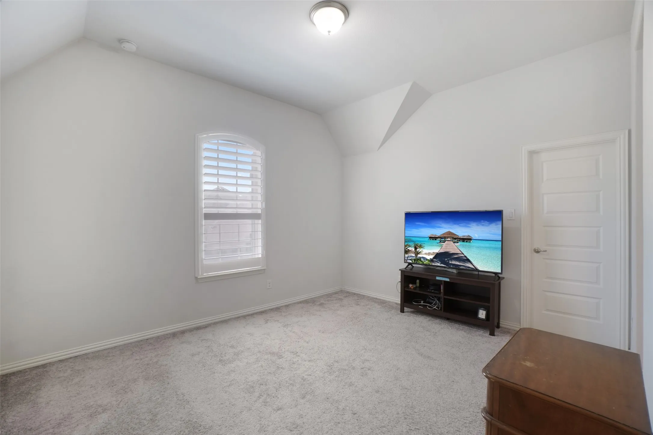 Carpeted living area with lofted ceiling