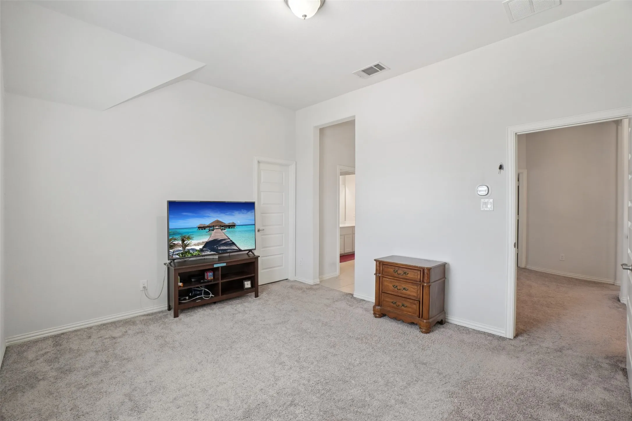 Carpeted living room featuring vaulted ceiling and baseboards