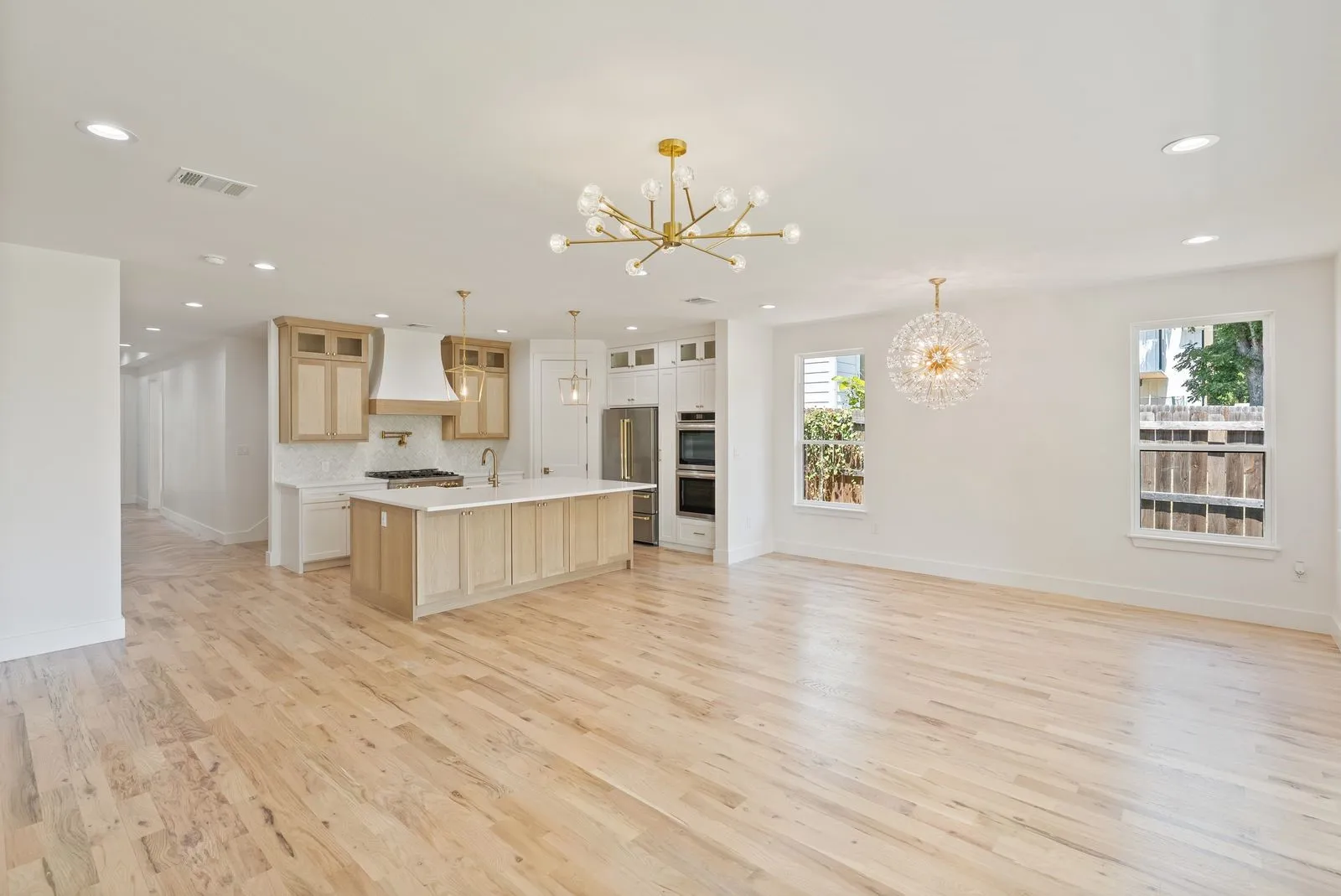Hardwood flooring throughout, recessed lighting, and a kitchen island with a built-in sink